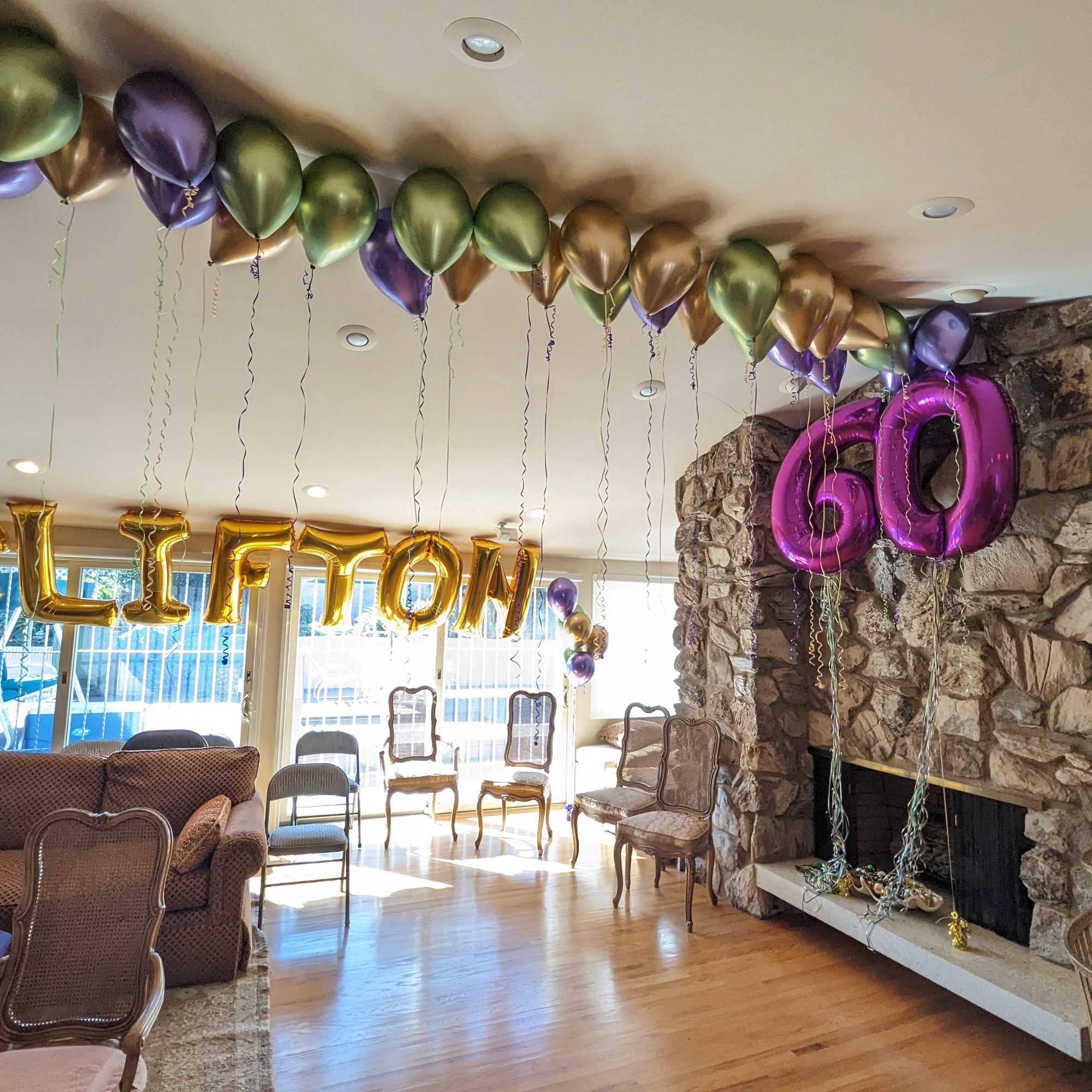 Balloon decorations spelling "CLIFTON" and "60" in a living room