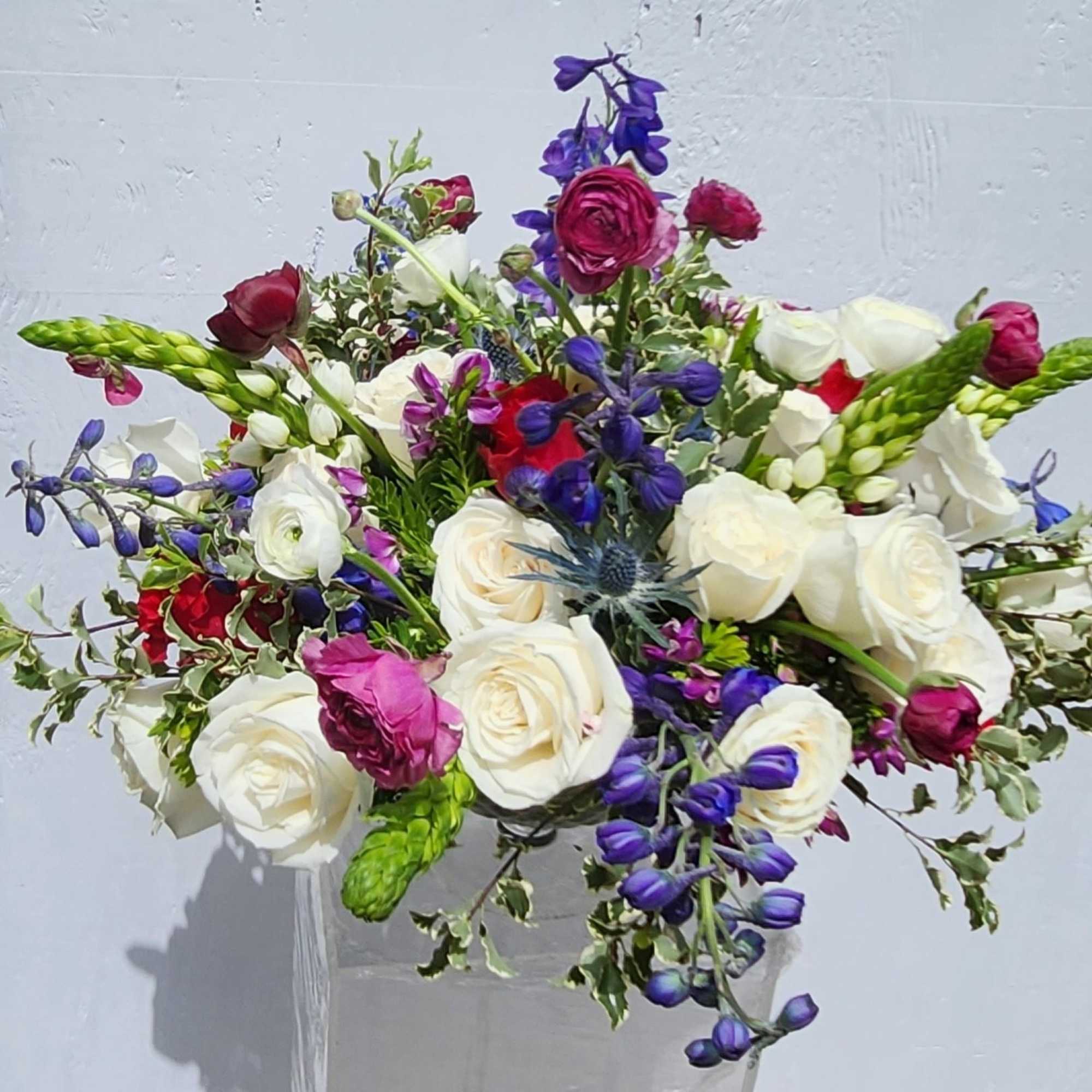 Bouquet of white, pink, and purple flowers in a clear vase