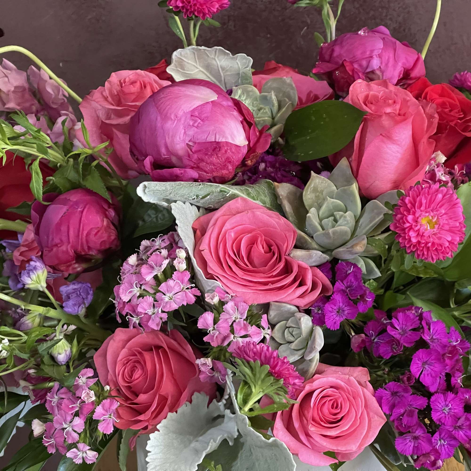 Bouquet of pink and red roses with purple flowers and succulents