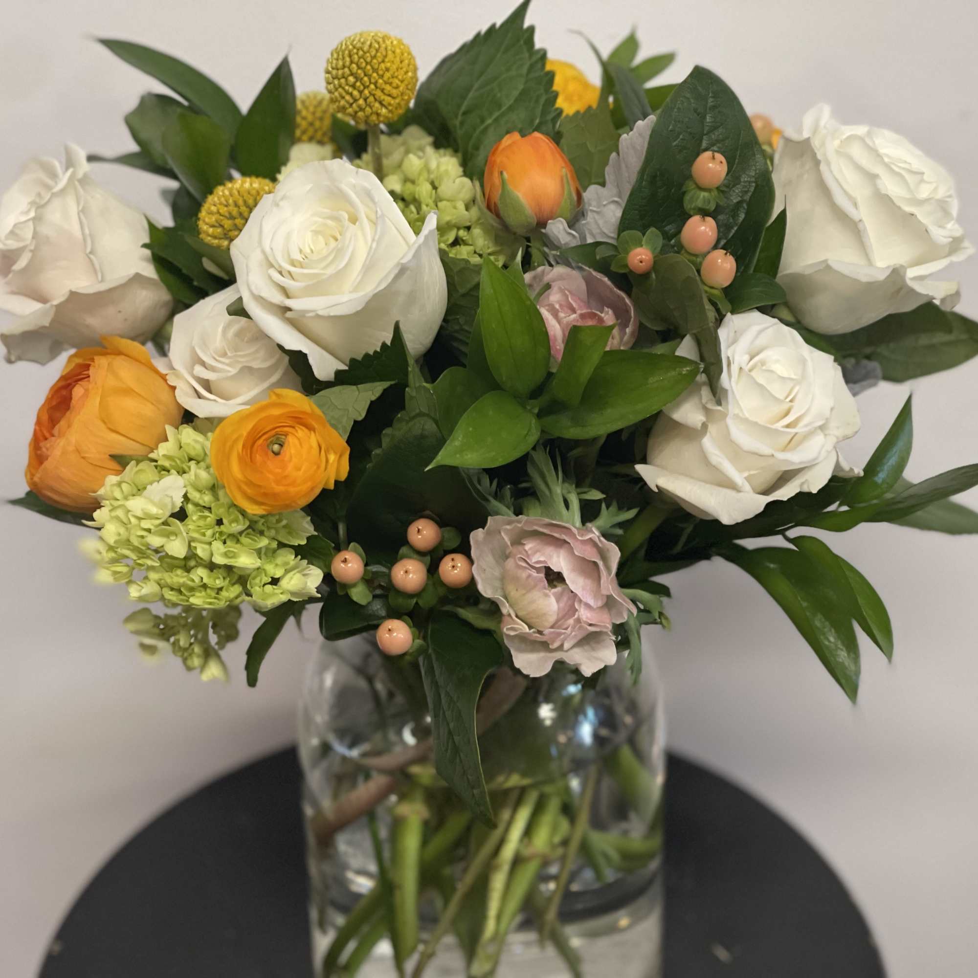 Mixed bouquet of white and orange flowers in a glass vase