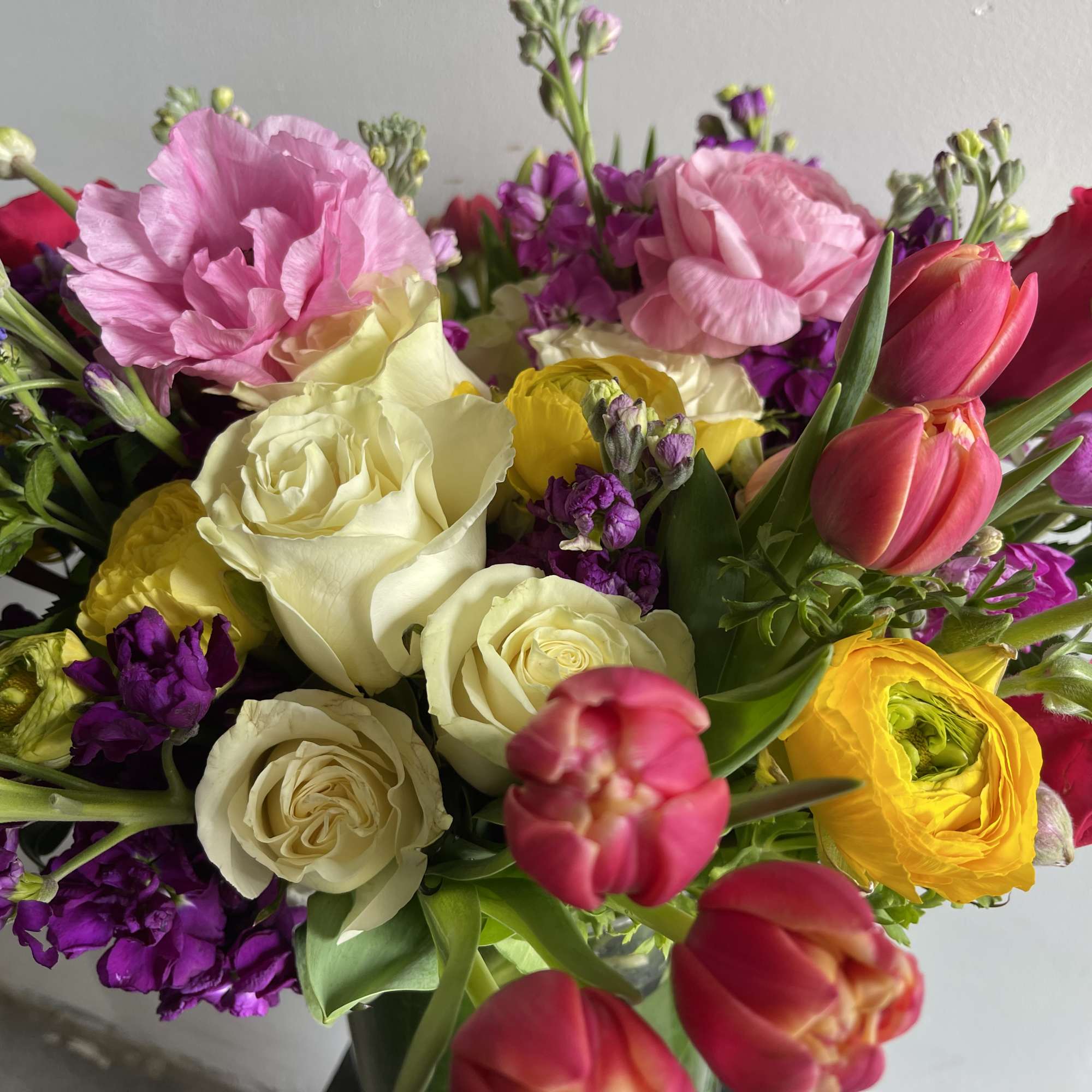 Mixed bouquet with roses, tulips, and pink blooms in bright colors