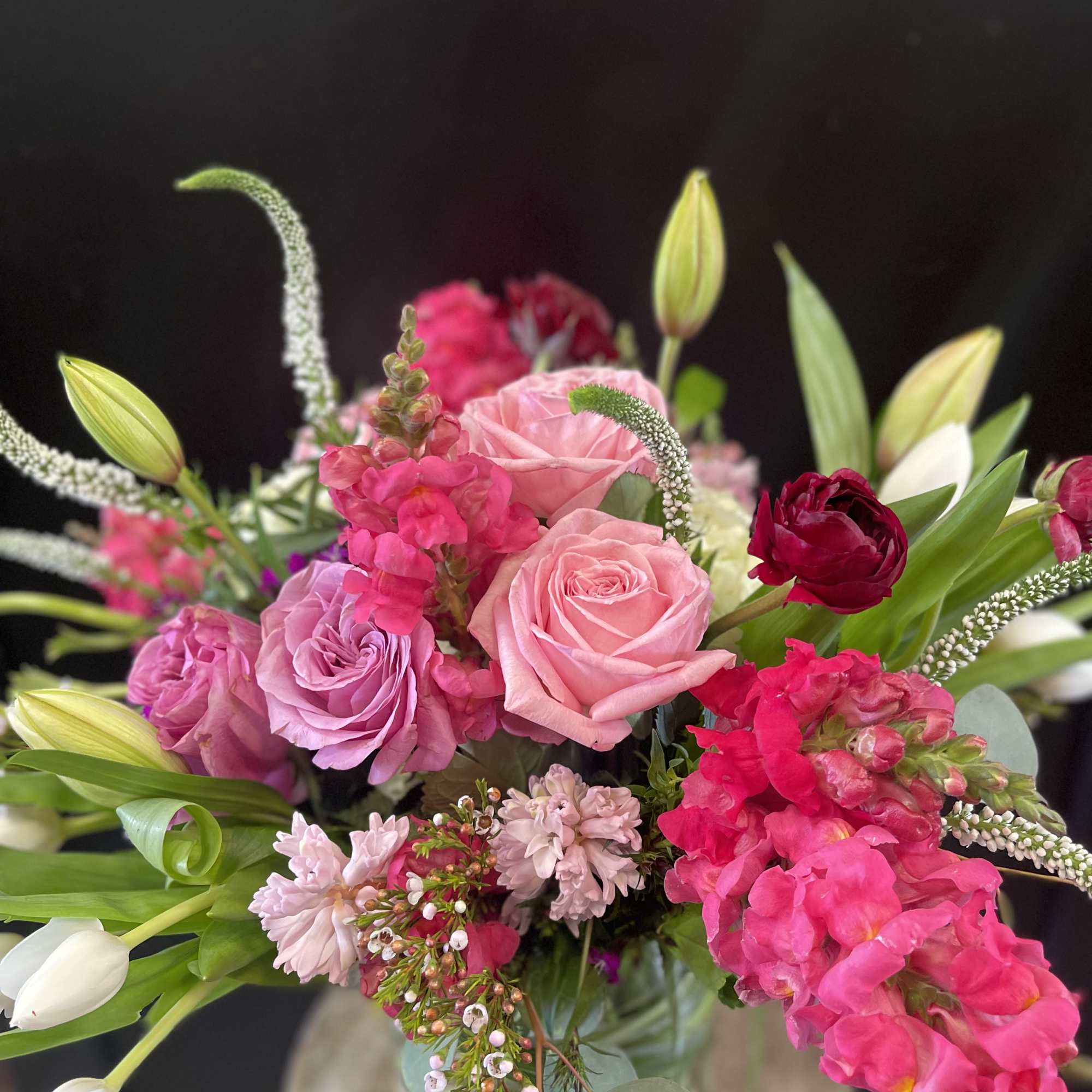 Pink and red roses with lilies and snapdragons in a bouquet