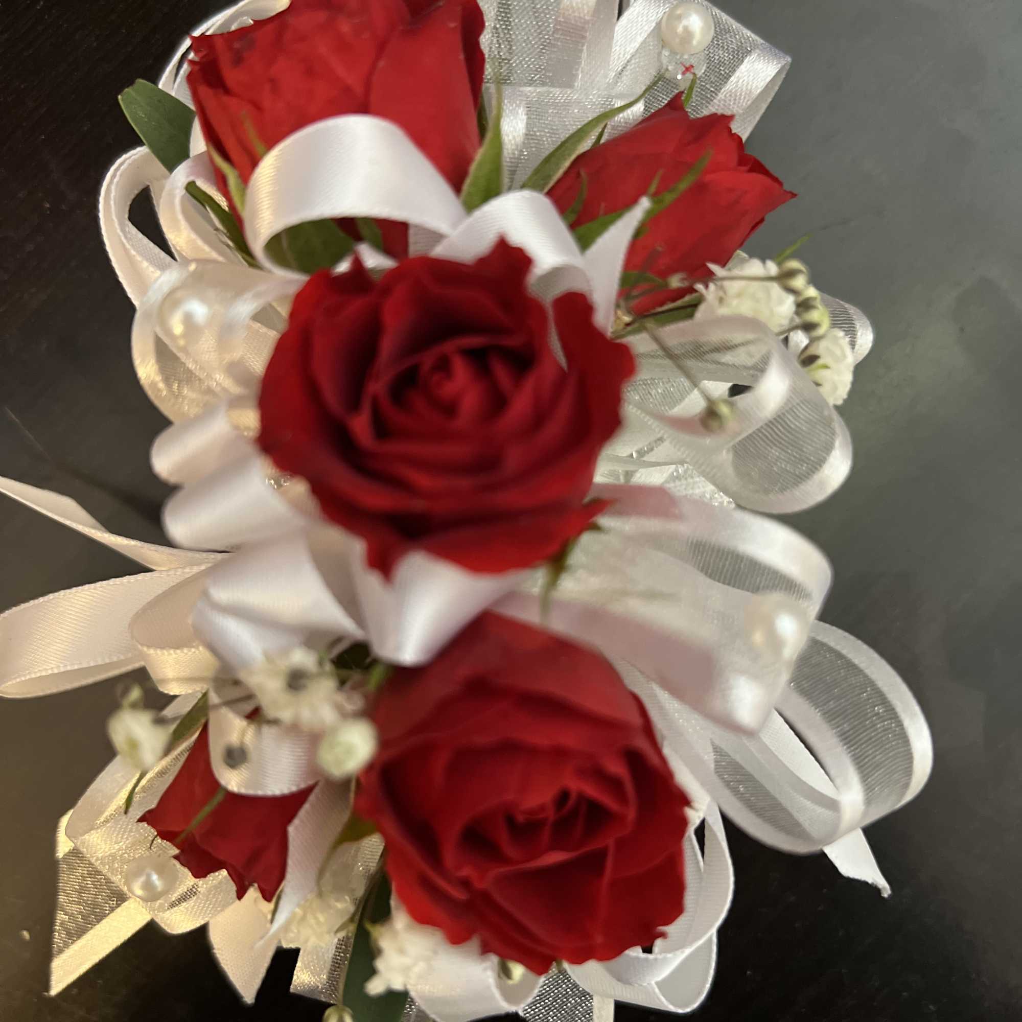 Small bouquet of red roses with white ribbon and pearl accents