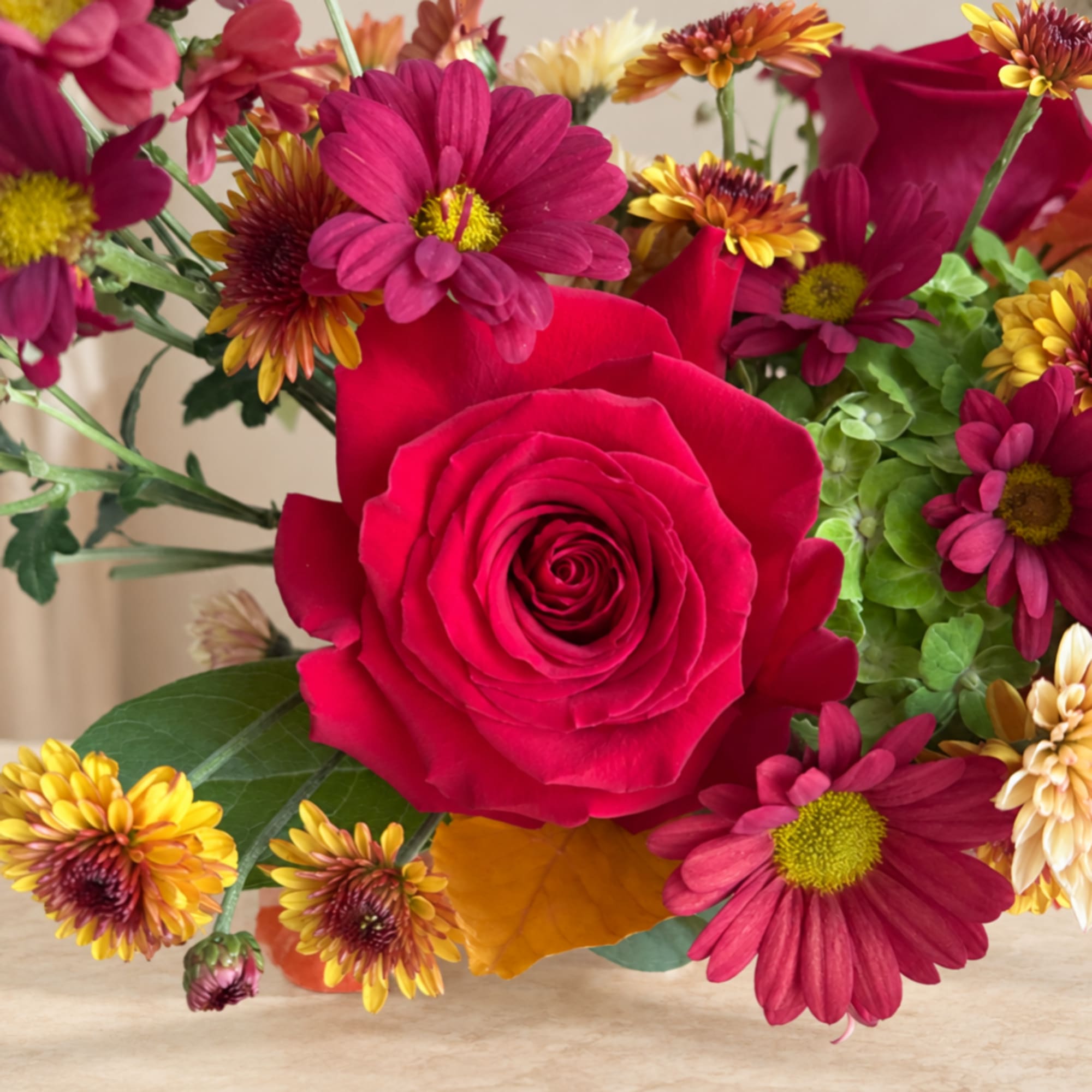 Bouquet with a red rose and magenta daisies in a vase