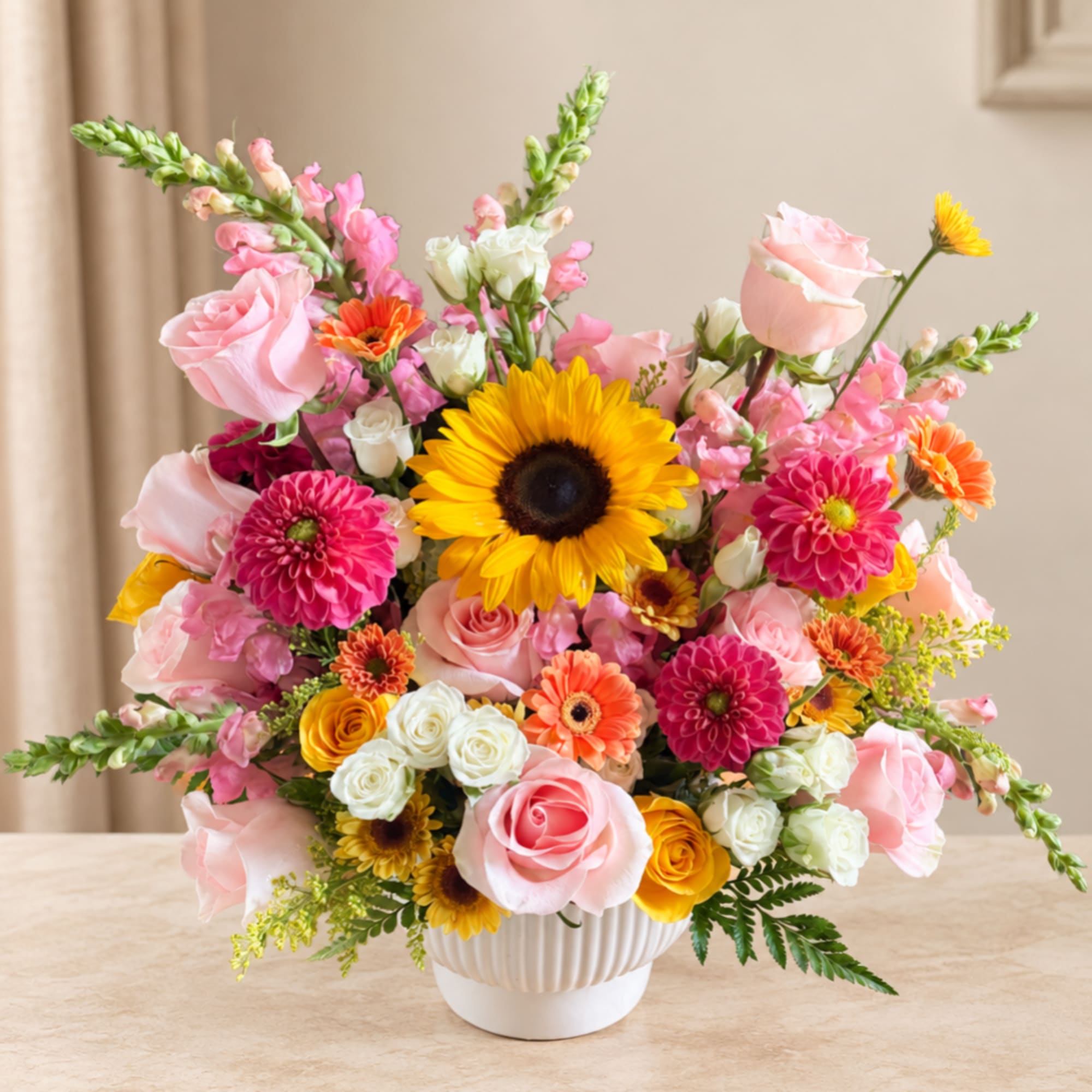 Pink and yellow mixed flower arrangement in a white vase