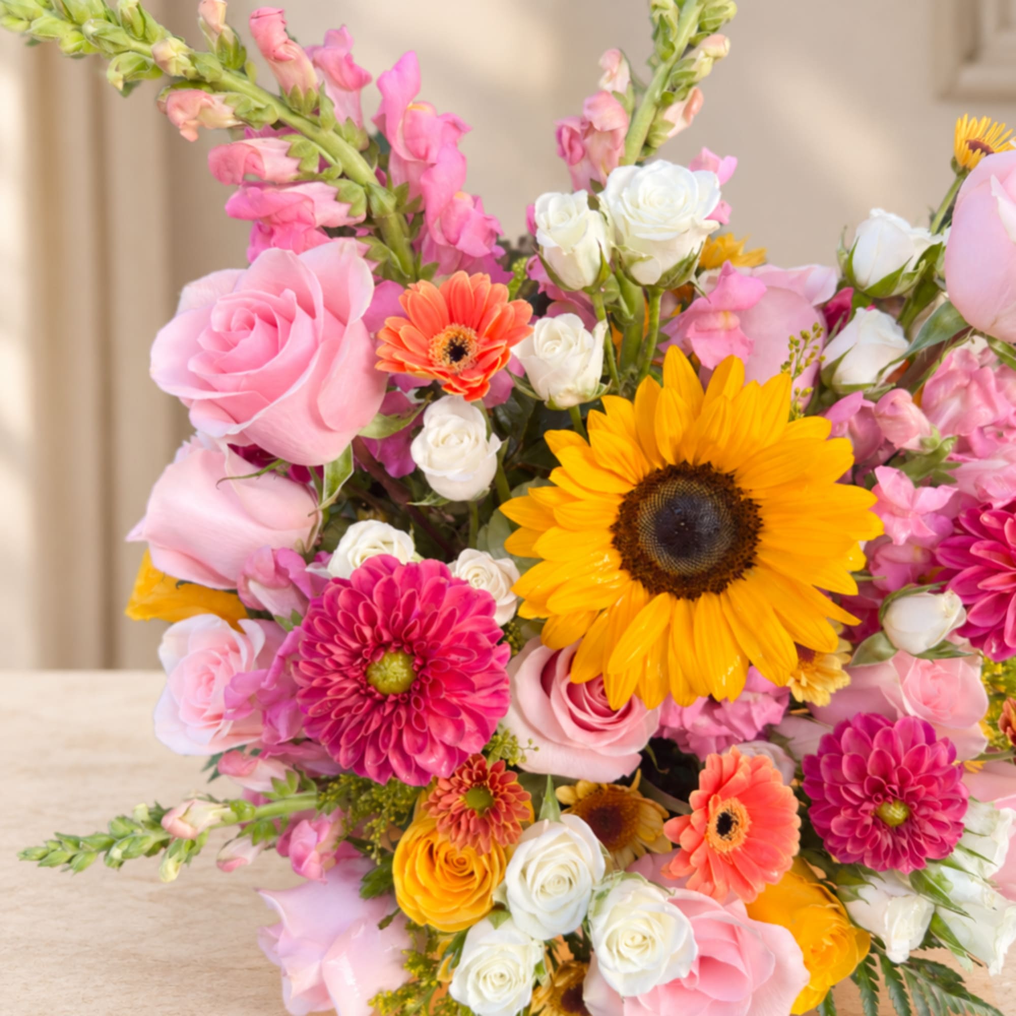 Mixed bouquet with pink roses, sunflowers, and white spray roses