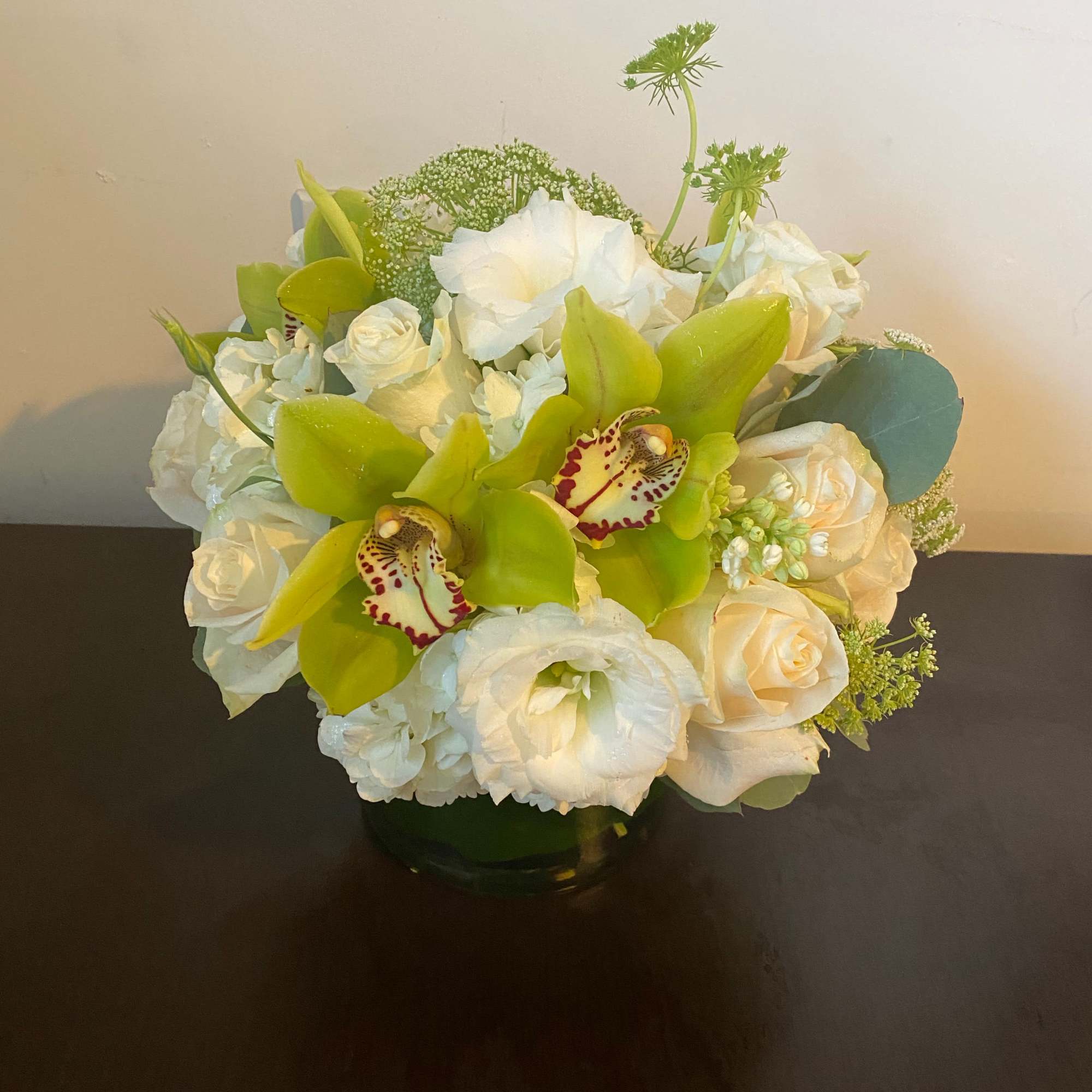 White and green floral arrangement in a glass vase