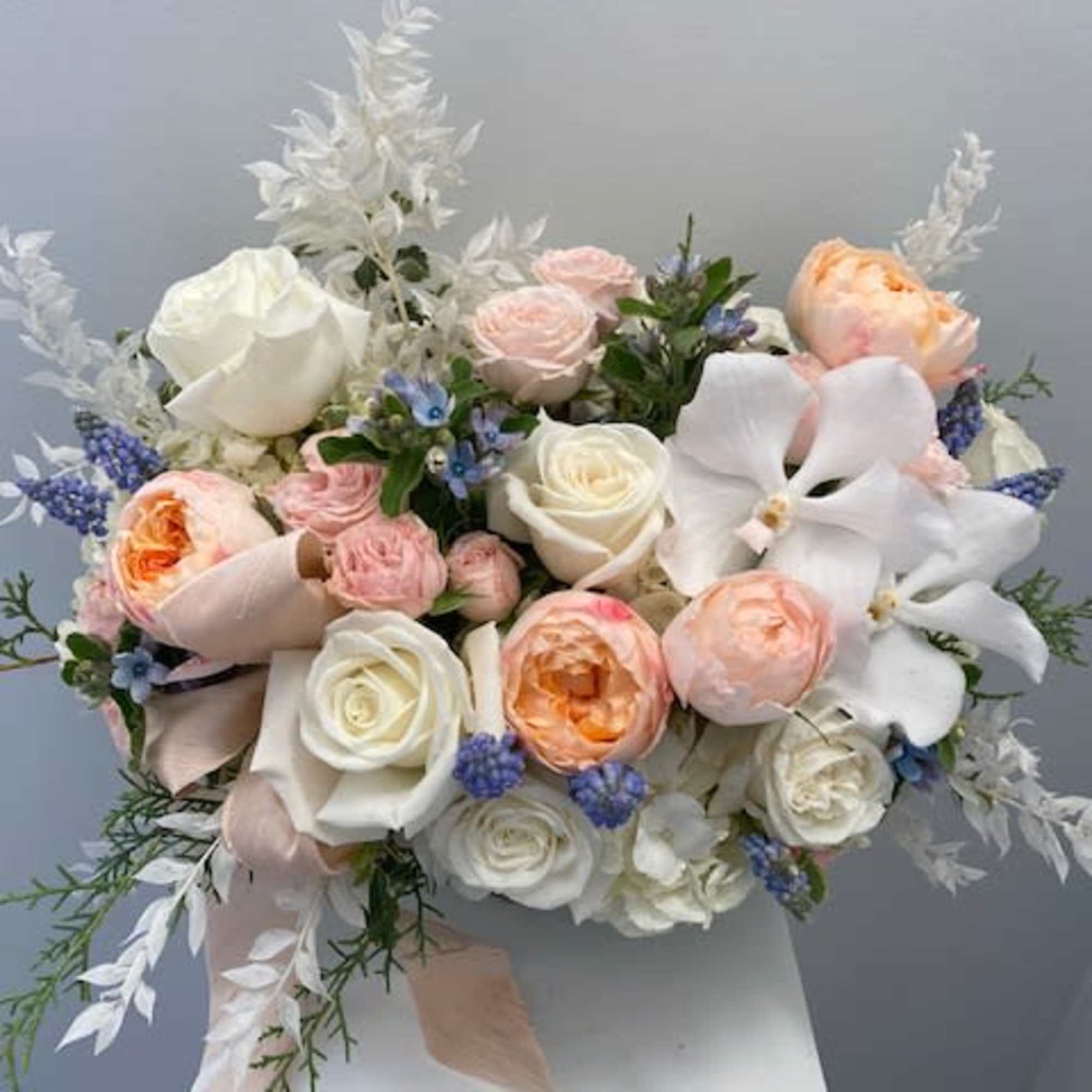 Pastel bouquet of roses and orchids with ribbon