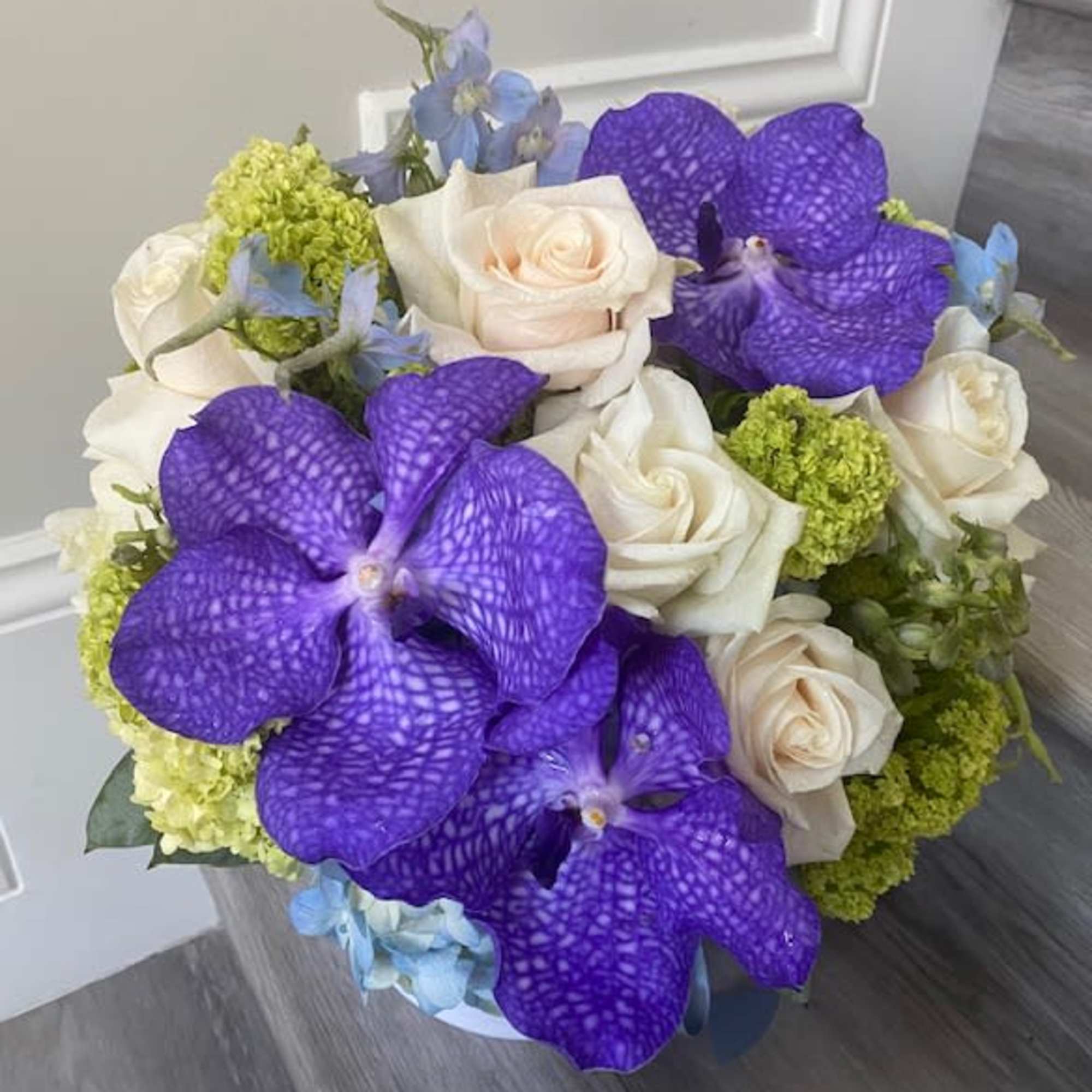 Bouquet of white roses, purple orchids, and blue flowers