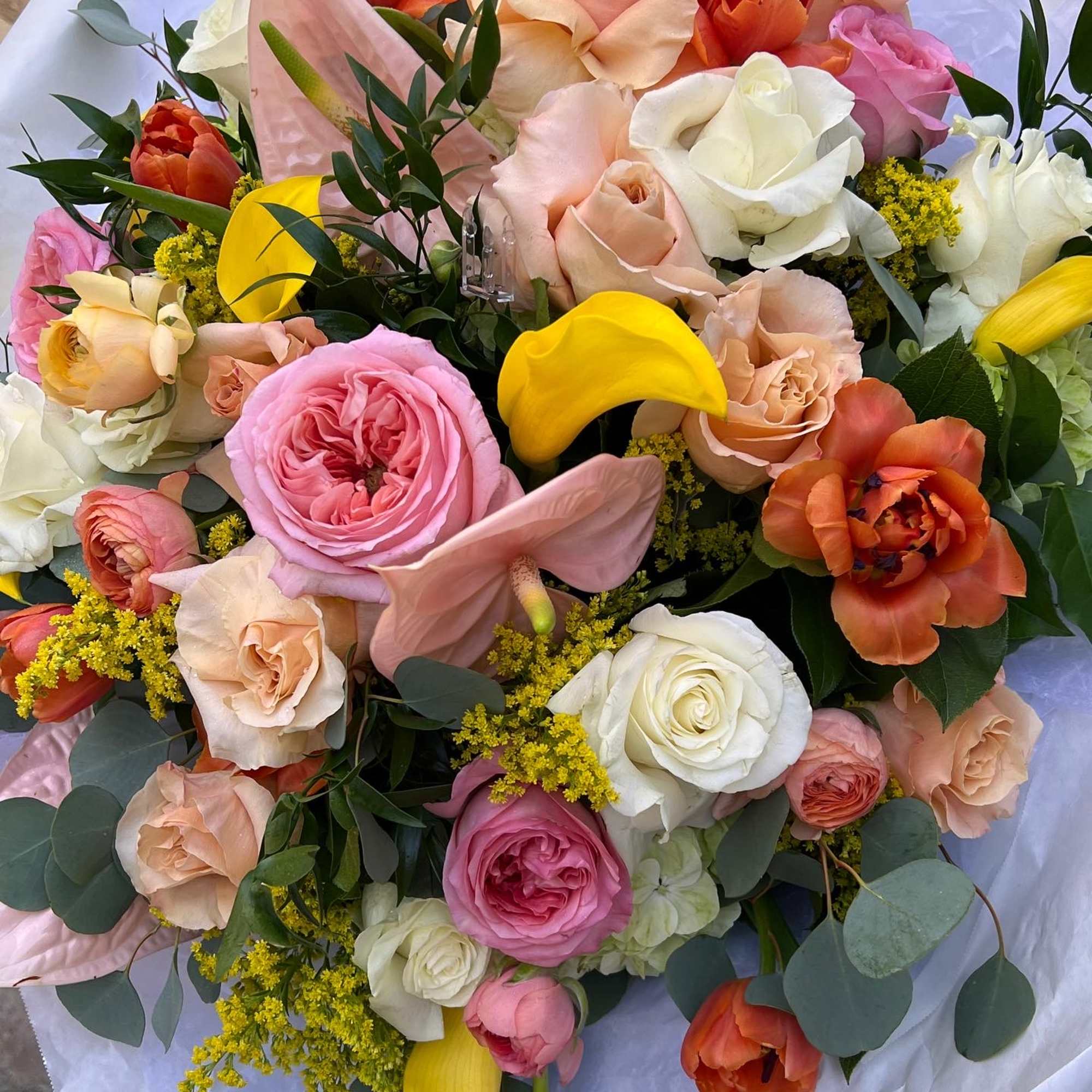 Bouquet of pink, peach, white, and yellow flowers with eucalyptus