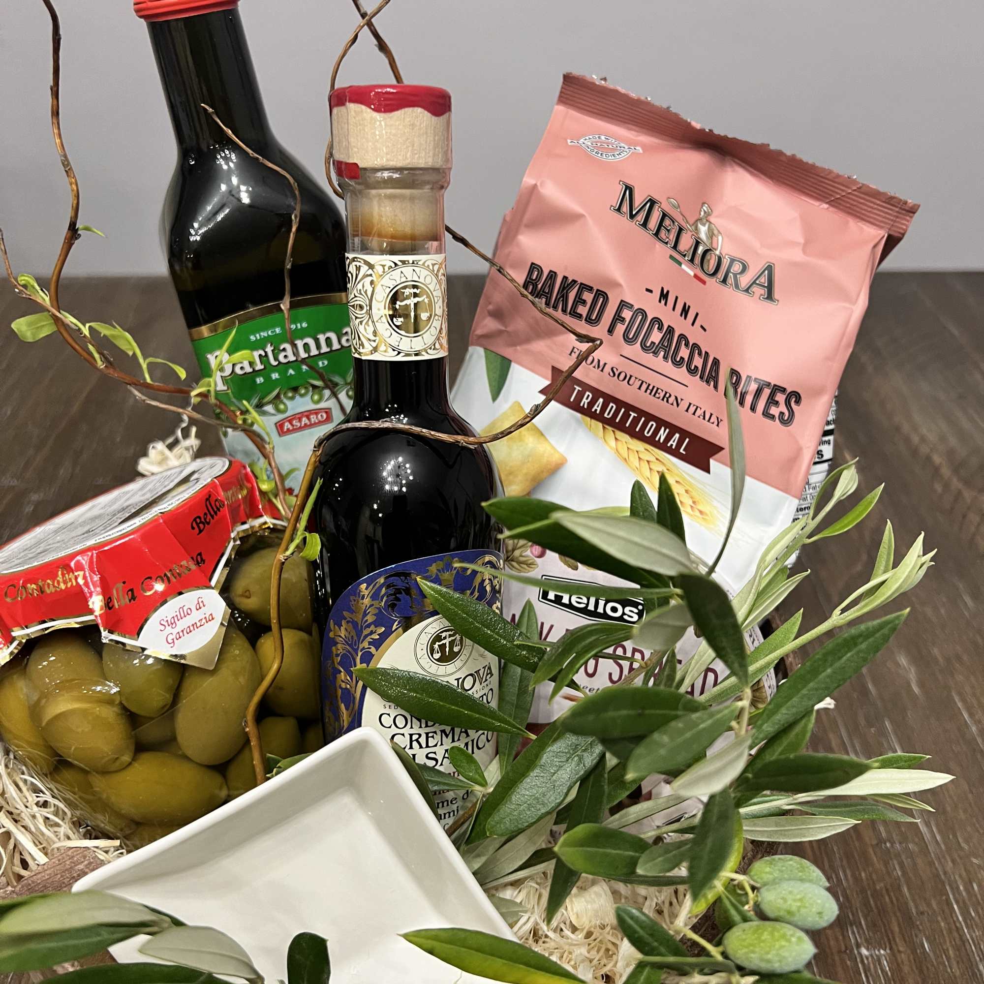 Gift basket with olives, olive oil, and packaged snacks