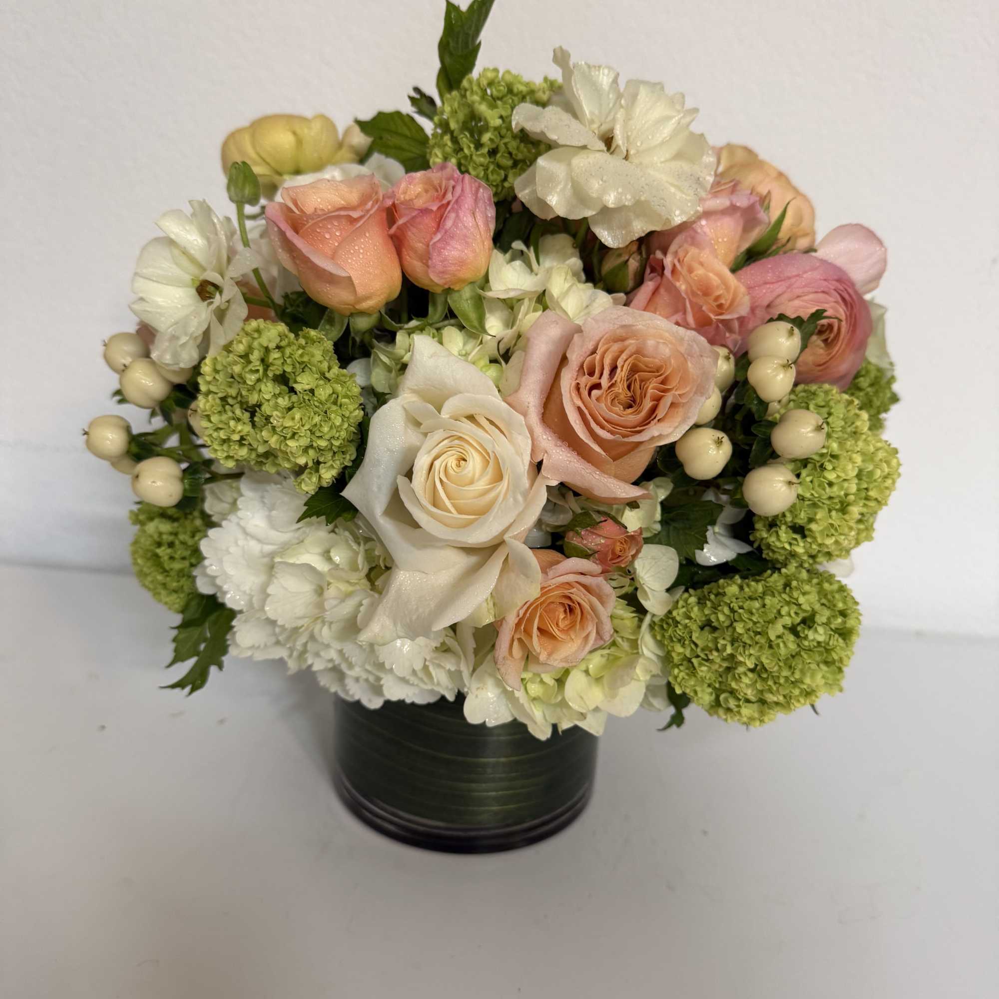 Bouquet of peach and white roses with green hydrangeas in a black vase, photo 2 of 2