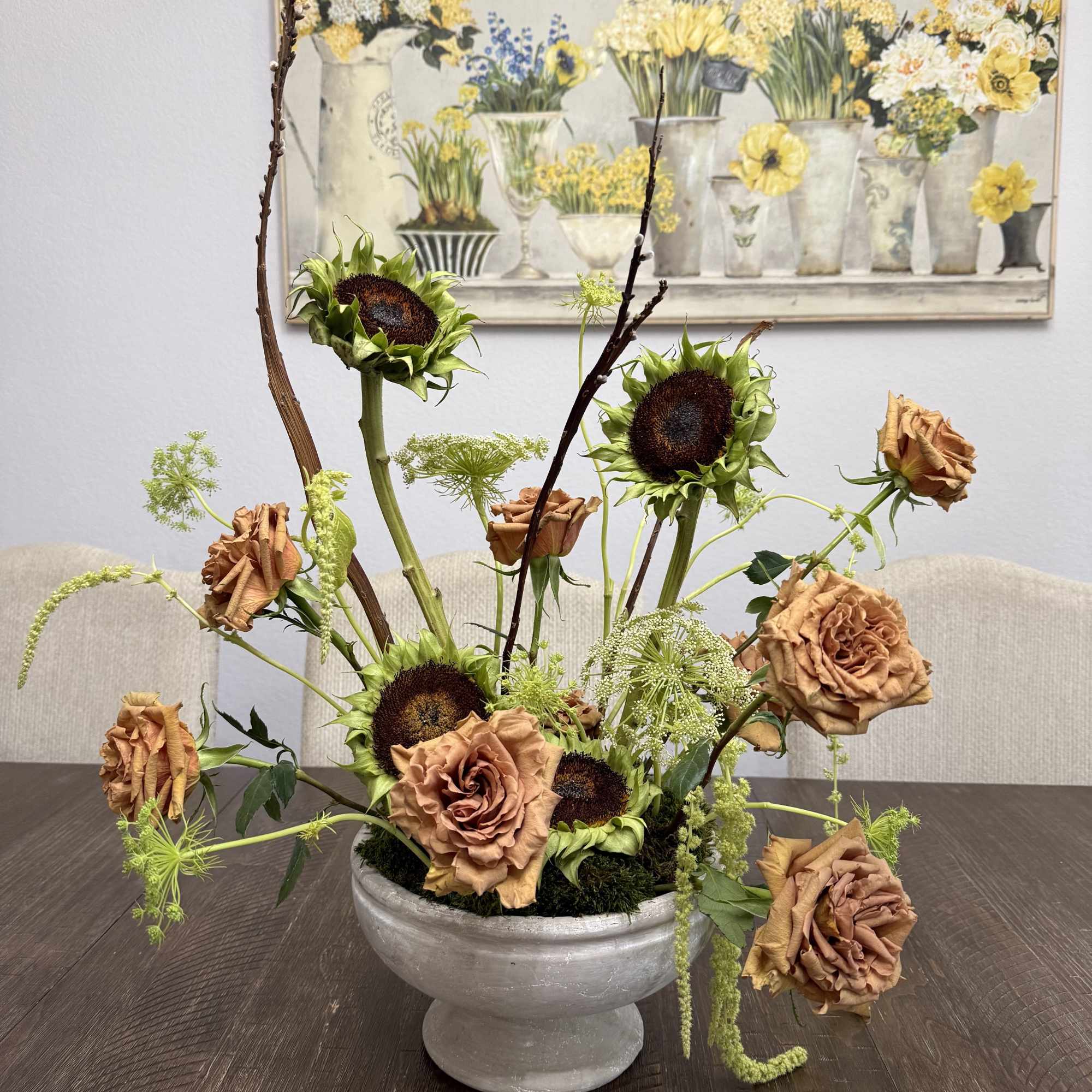 Arrangement of sunflowers and copper roses in a gray pedestal bowl
