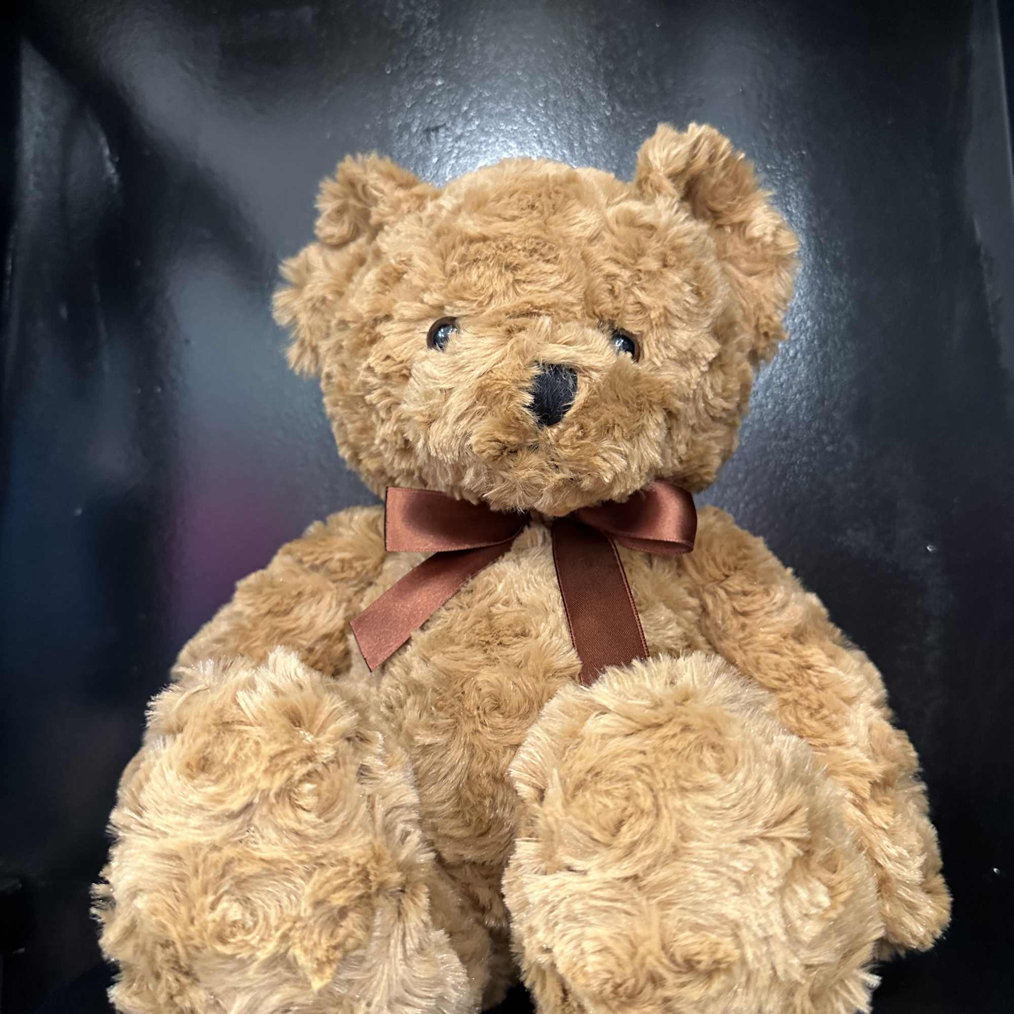 Brown teddy bear with a satin ribbon bow