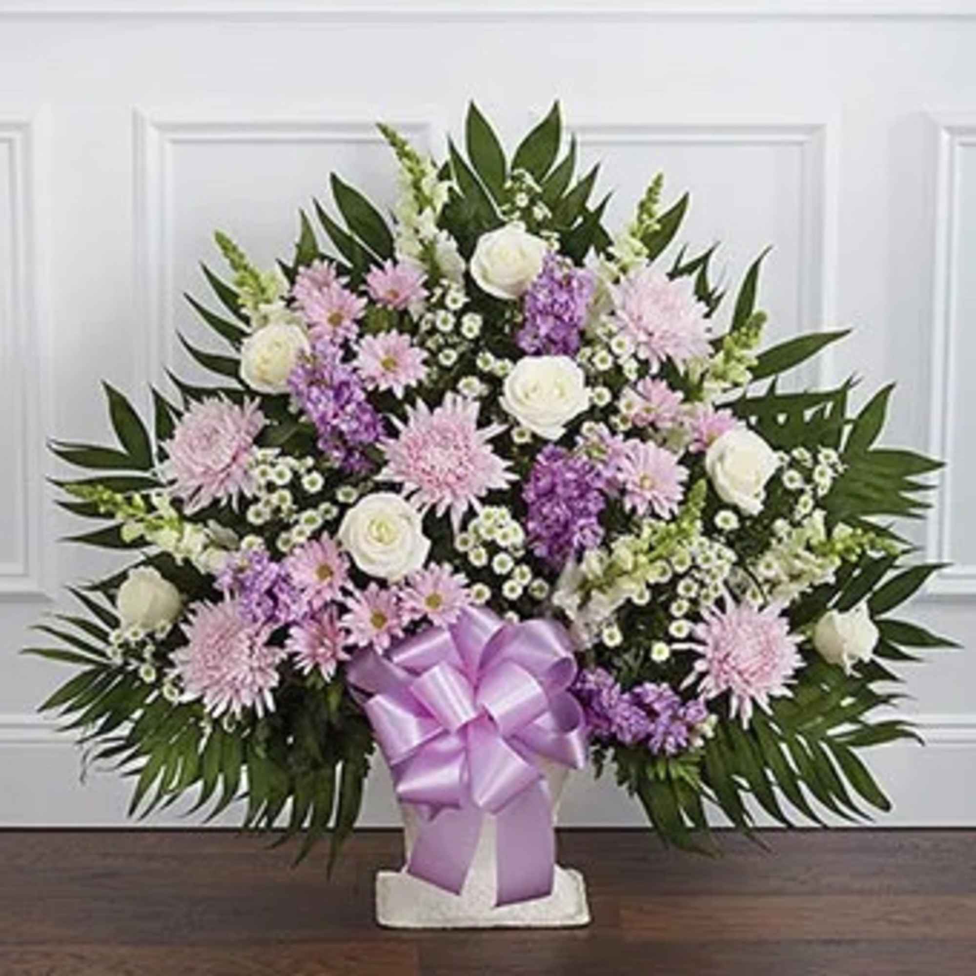 Lavender and white floral standing spray with a purple ribbon bow