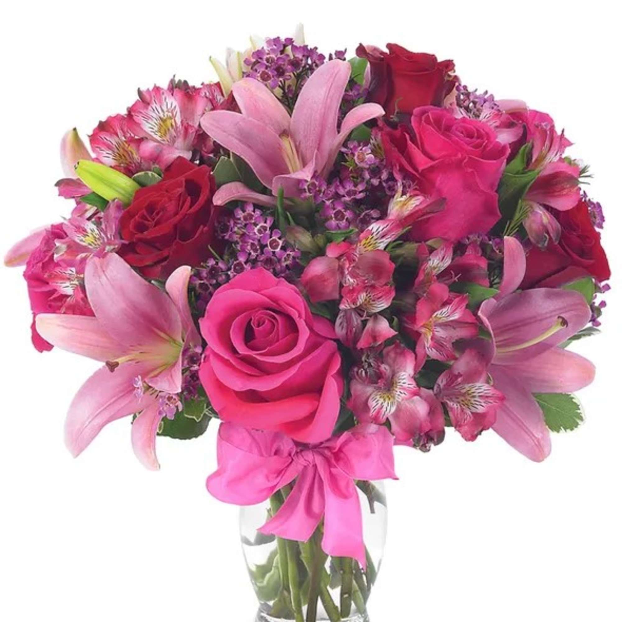 Pink and red bouquet of roses and lilies in a clear glass vase