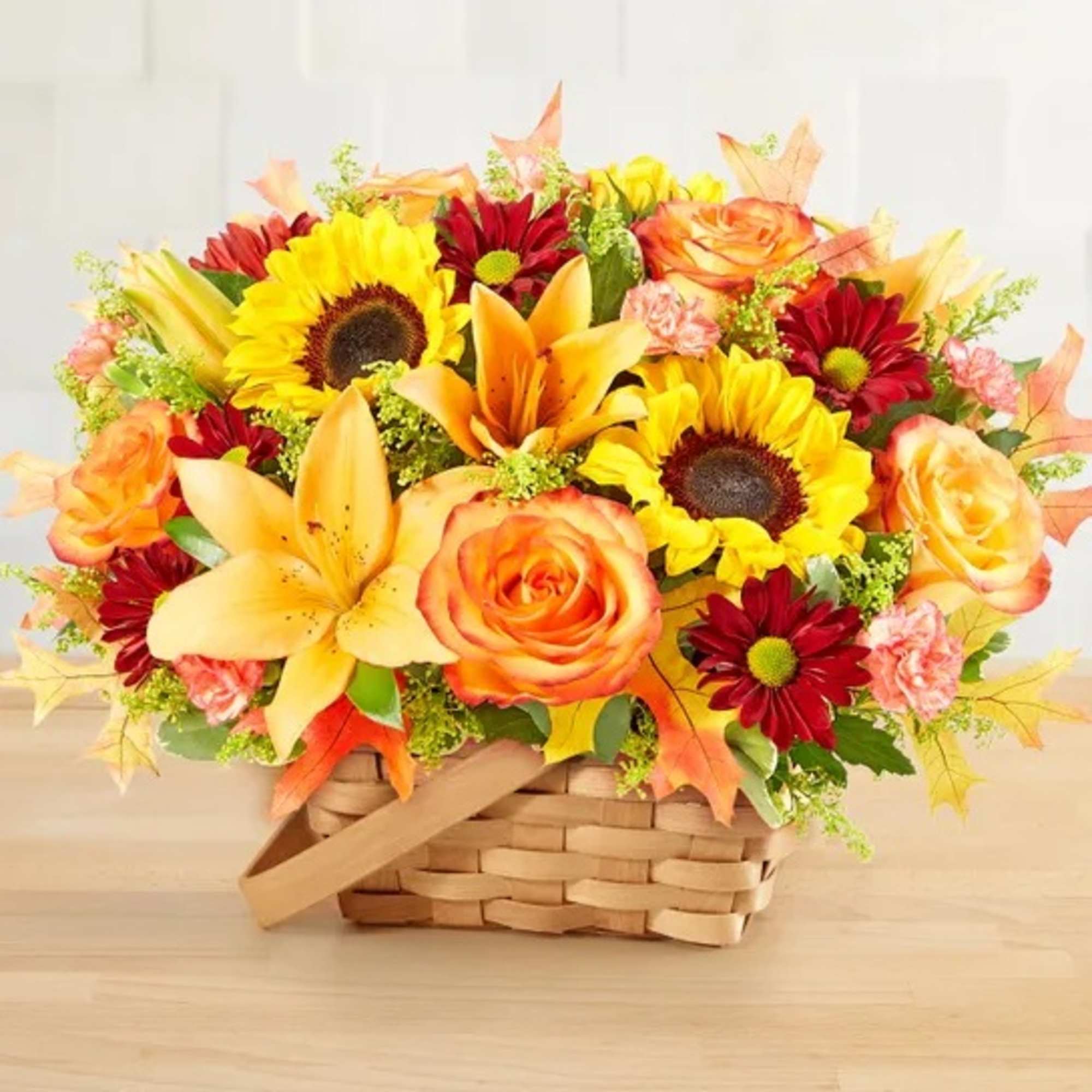 Basket arrangement of sunflowers, roses, lilies, and red daisies
