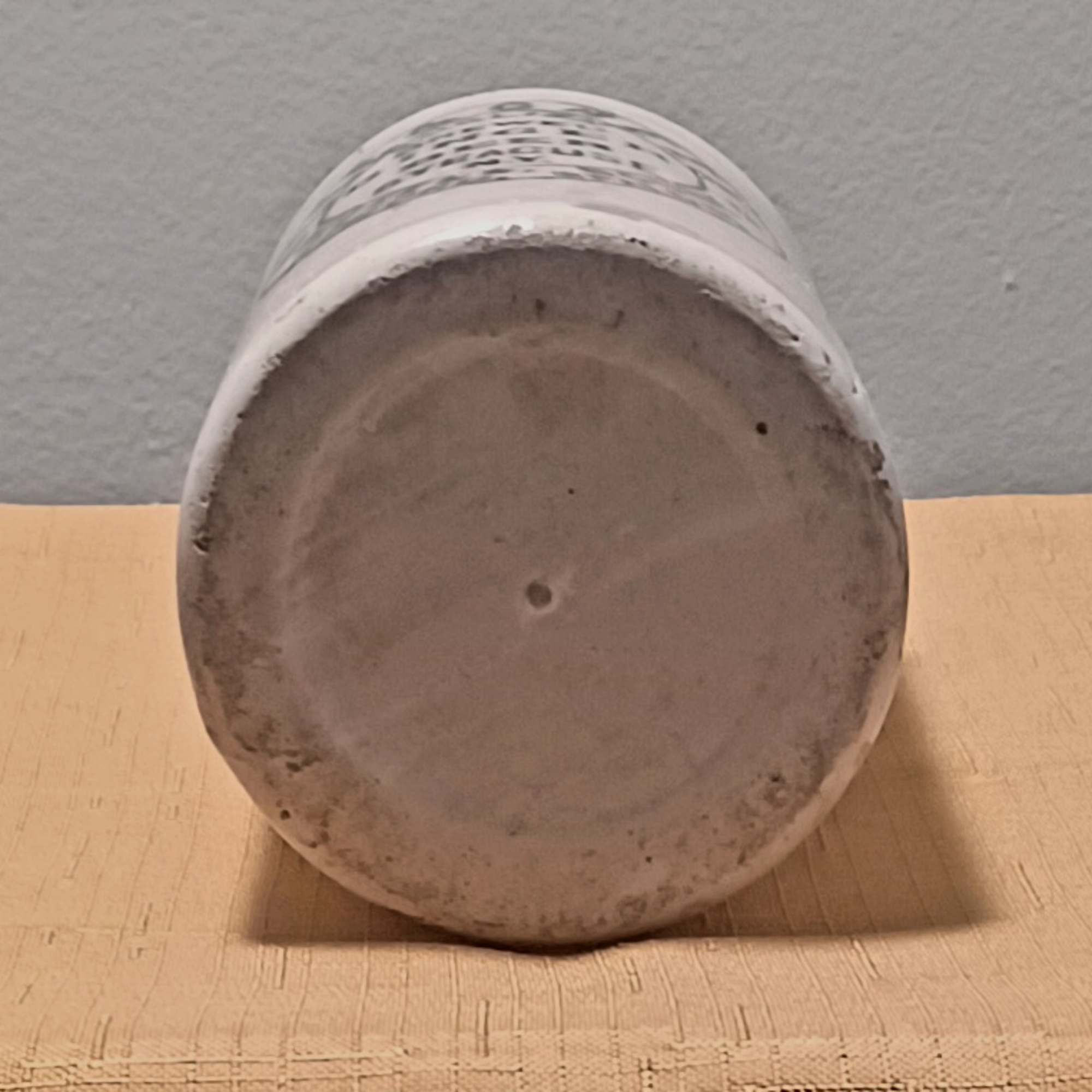 Upside-down white ceramic pot on a wooden surface