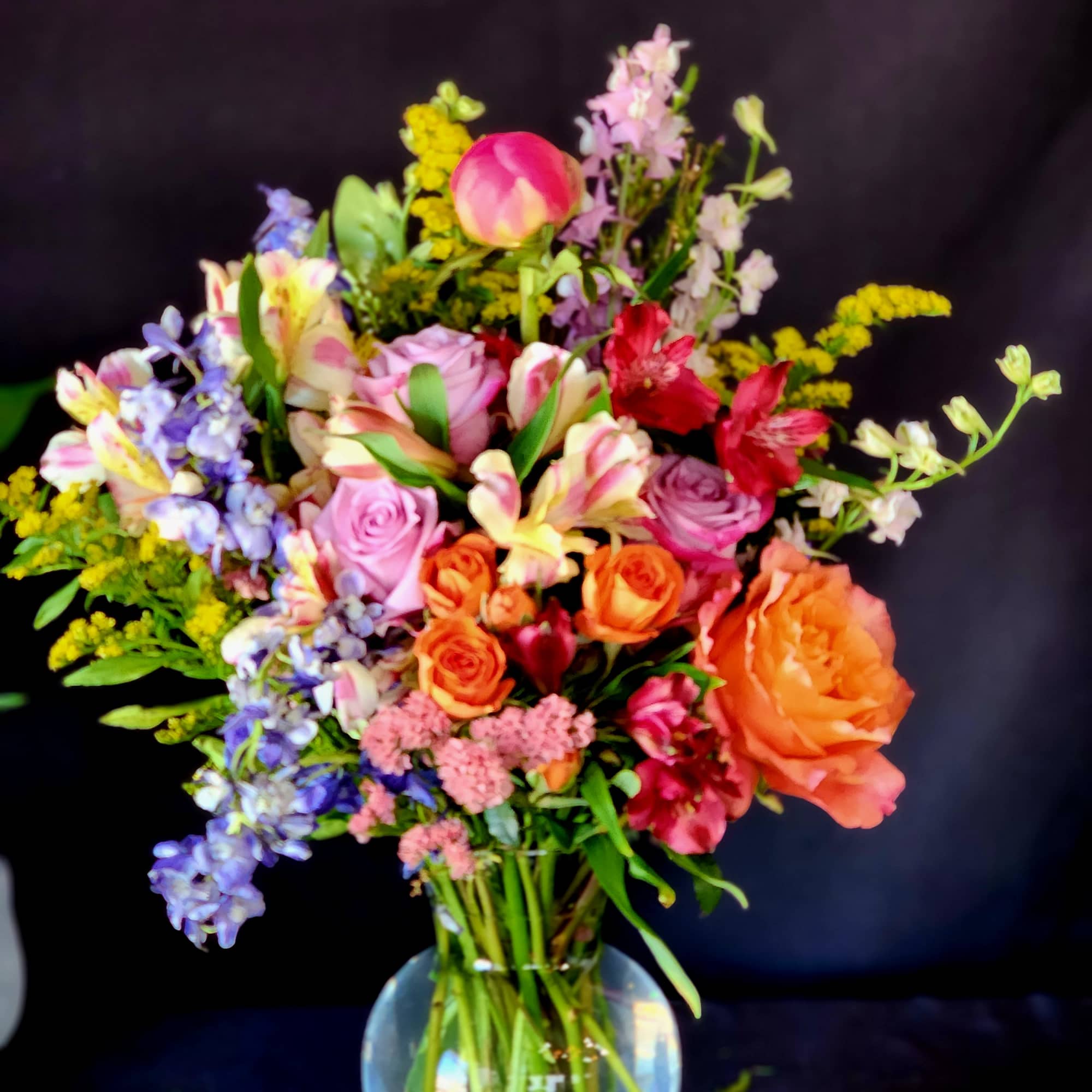Mixed bouquet of colorful flowers in a clear glass vase