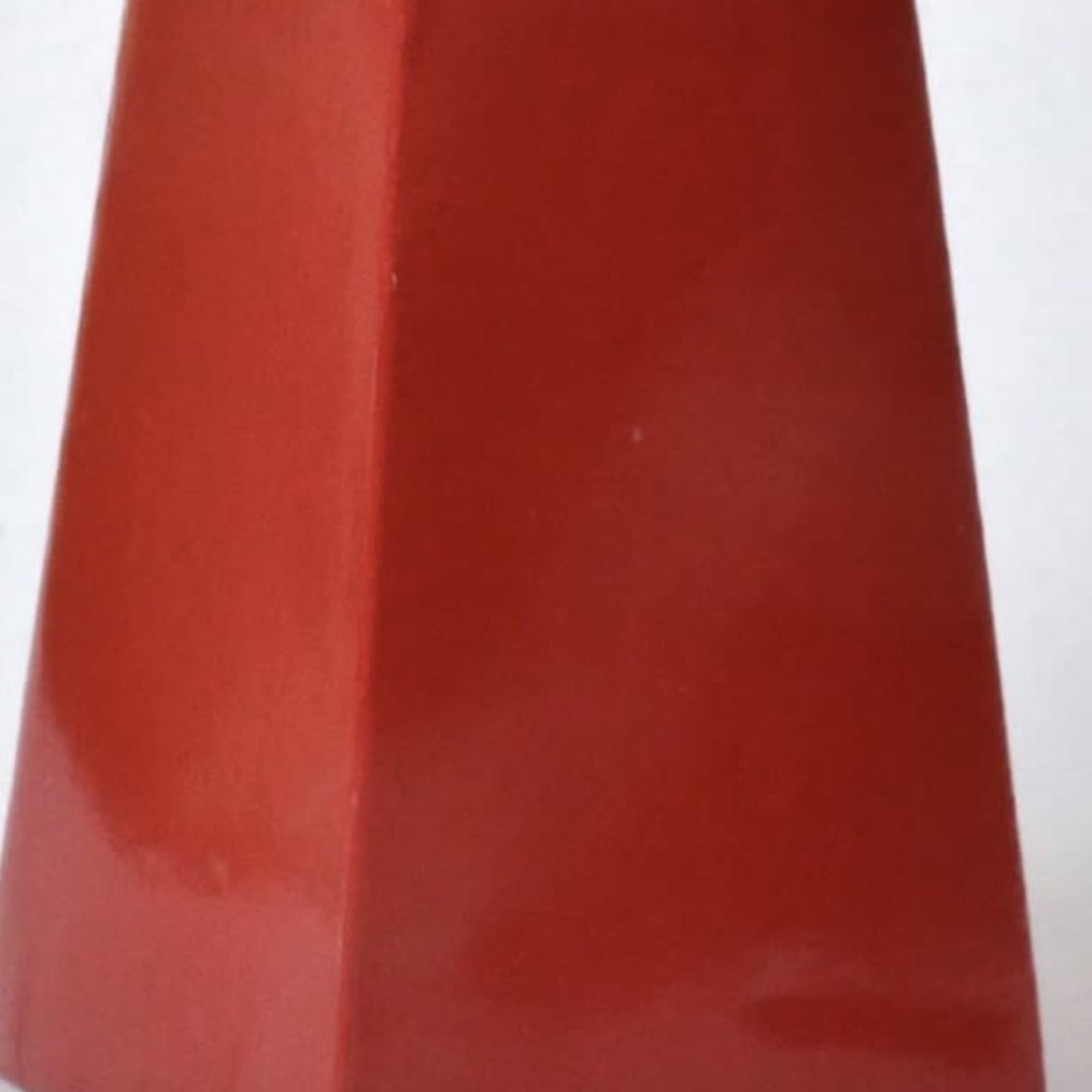 Tall red tapered rectangular container with open top on a light background