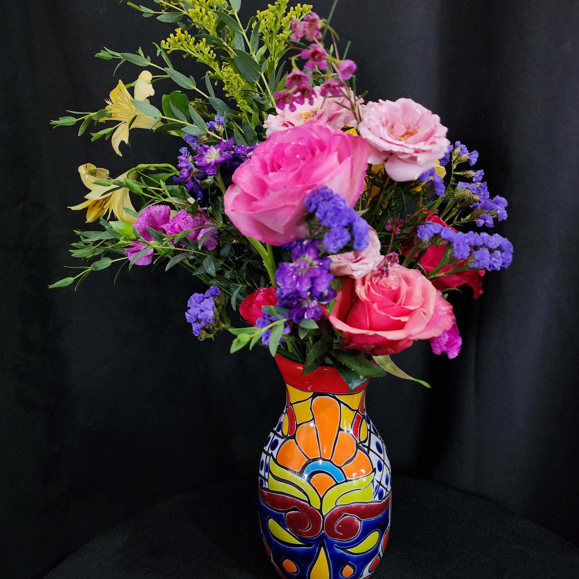 Colorful mixed bouquet in a painted ceramic vase with pink and purple blooms