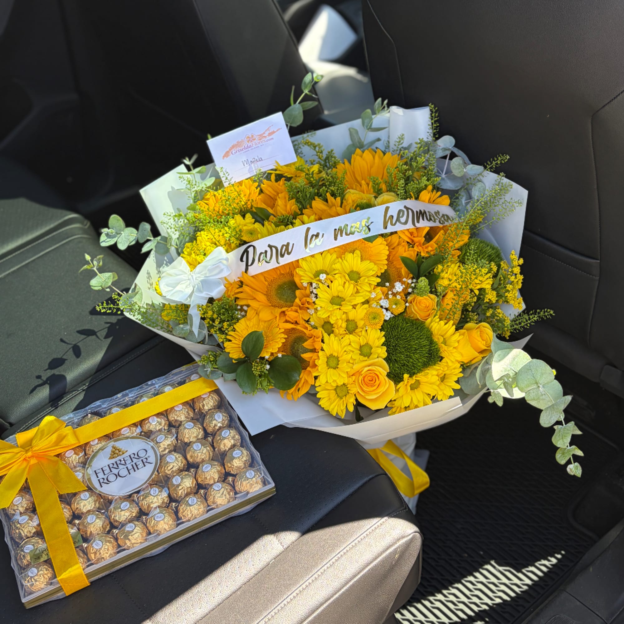 Yellow flower bouquet with a Ferrero Rocher box in a car seat