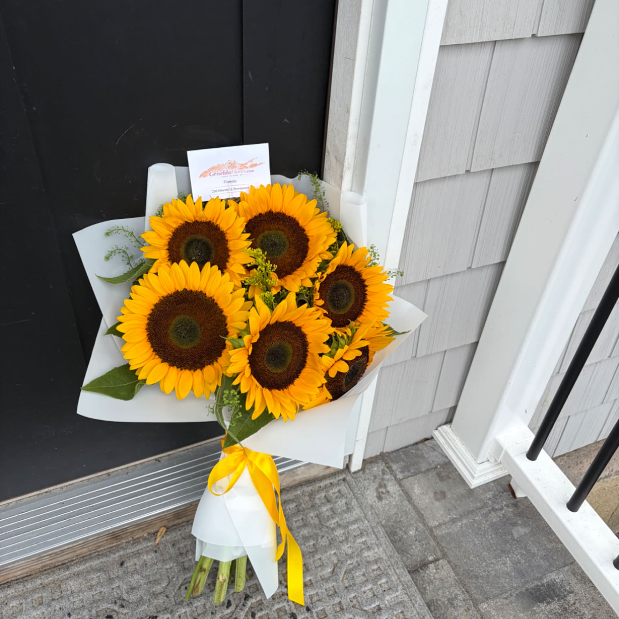 Bouquet of sunflowers wrapped in white paper with a yellow ribbon, photo 2 of 3