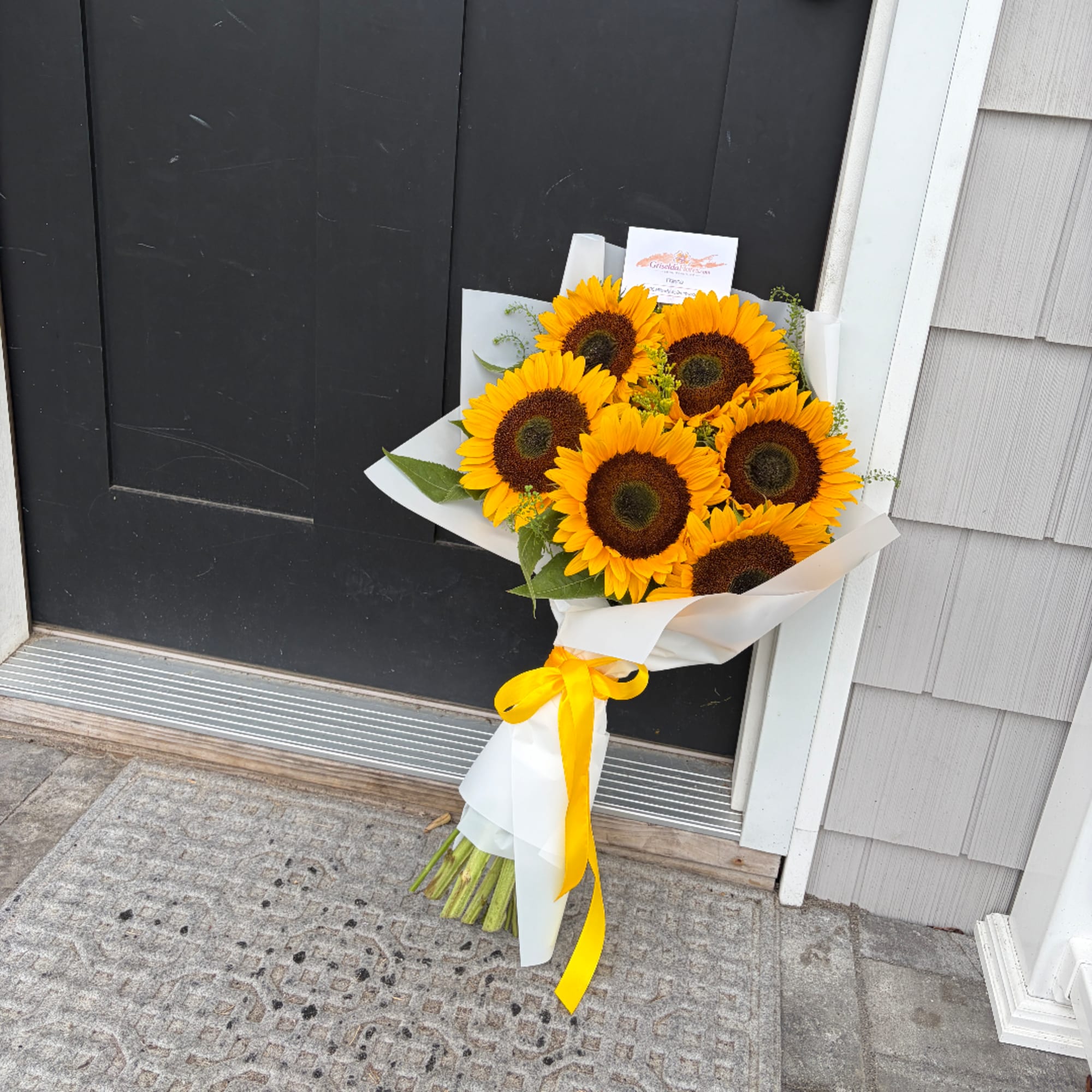Bouquet of sunflowers wrapped in white paper with a yellow ribbon, photo 3 of 3