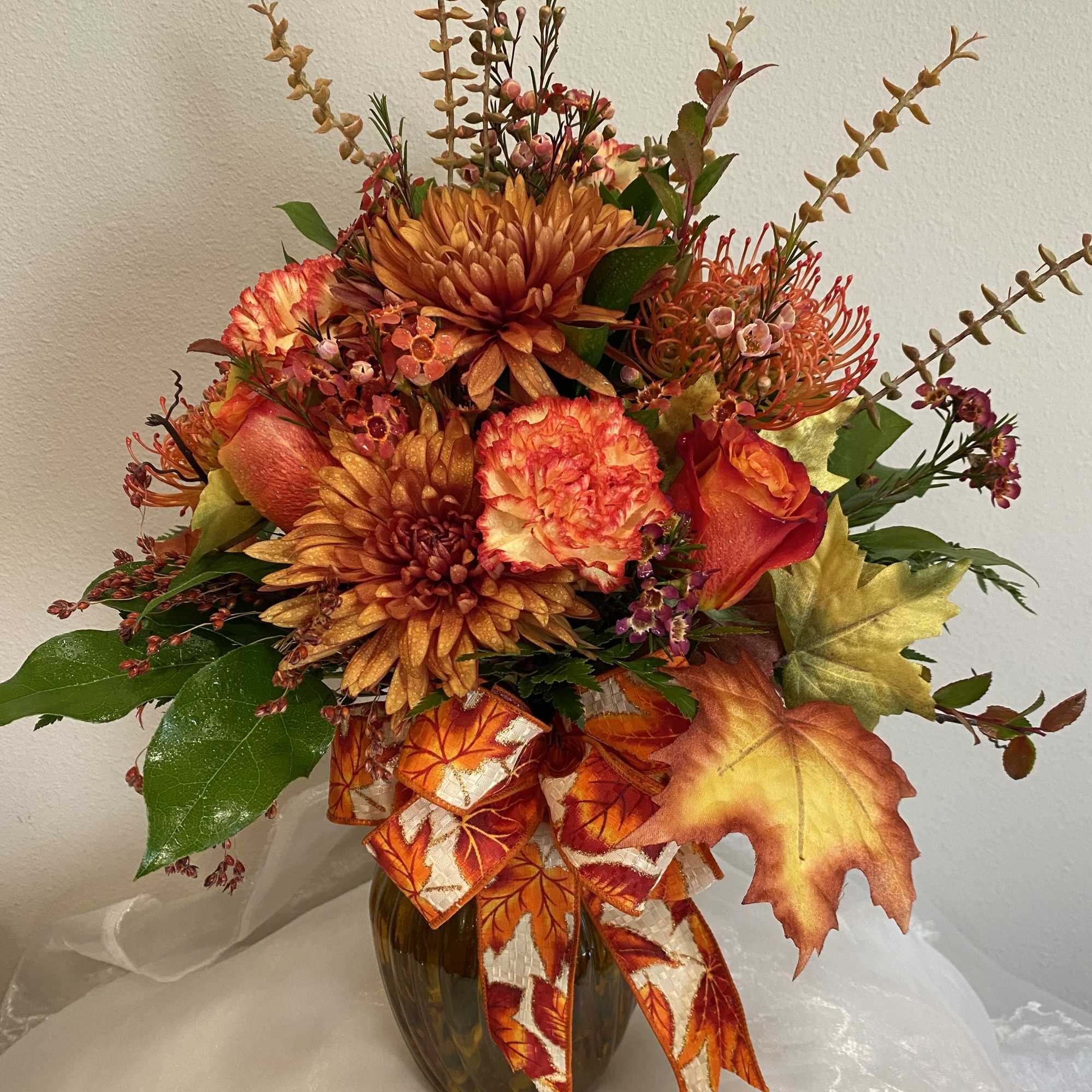 This vase arrangement has all the beautiful colors of fall.
Roses, carnations, protea