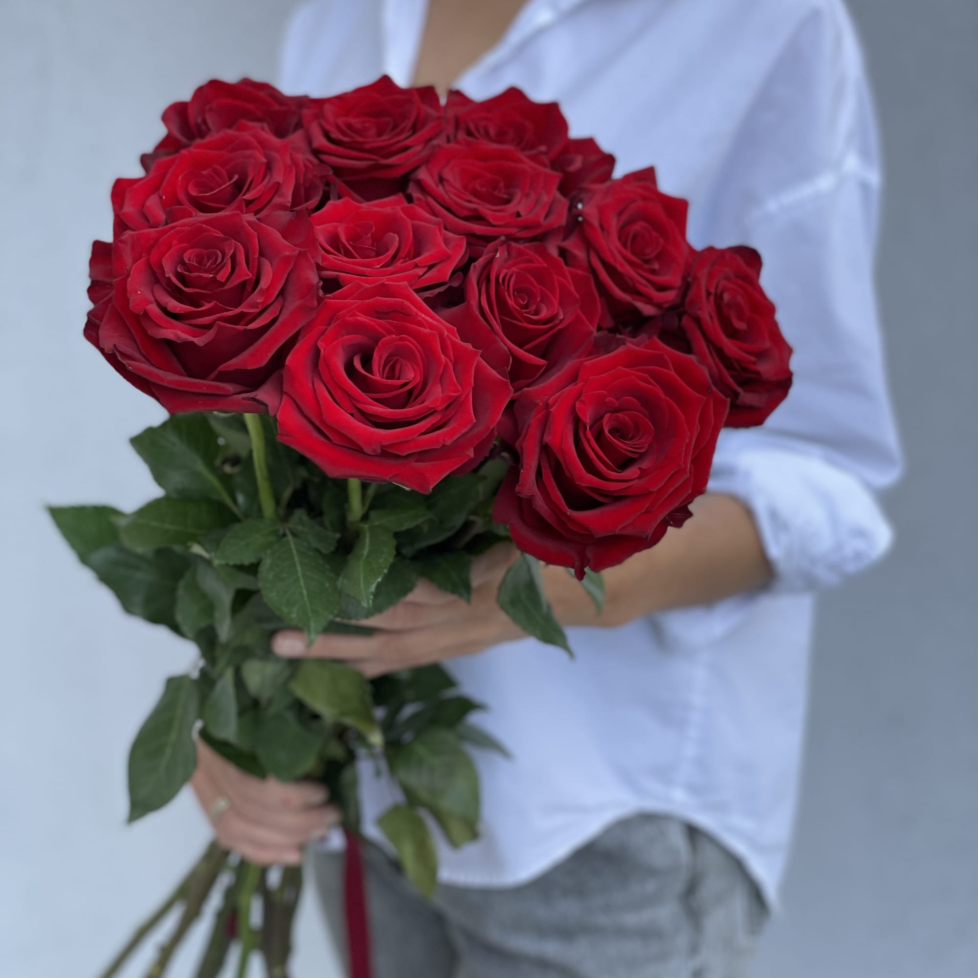 Bouquet of red roses held by a person