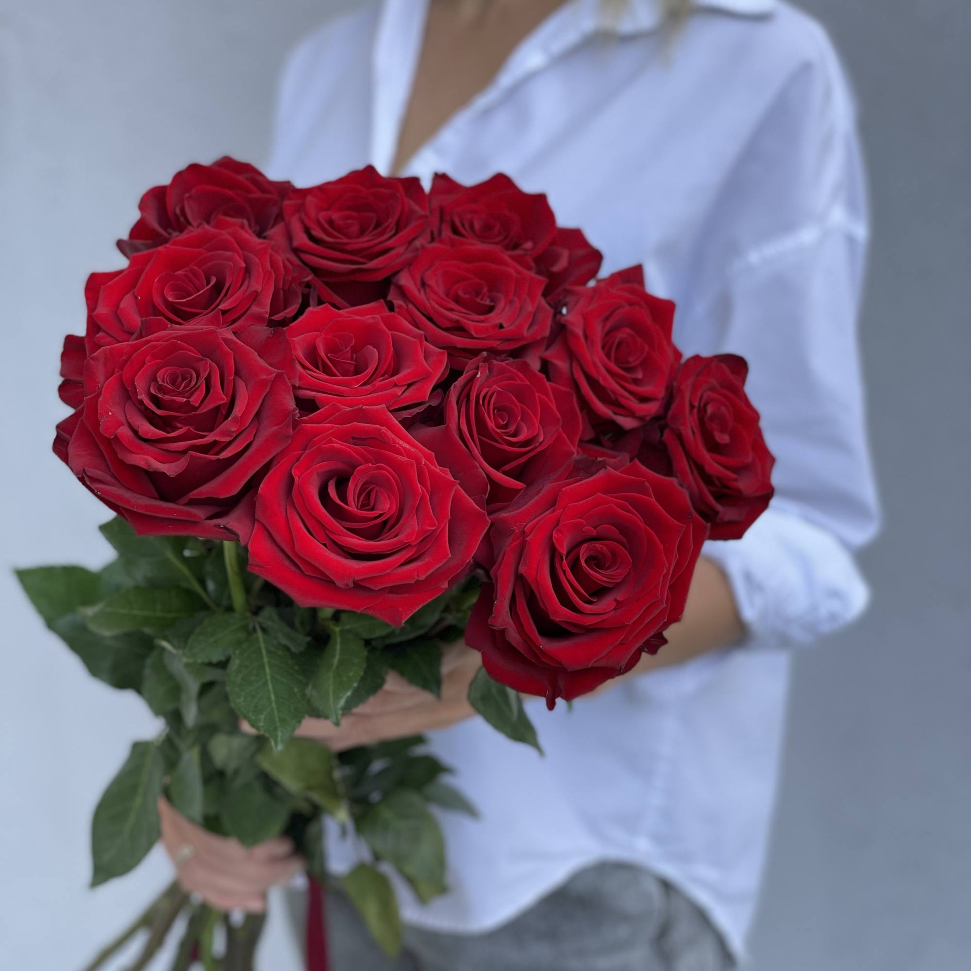Bouquet of red roses held by a person in a white shirt, photo 4 of 13
