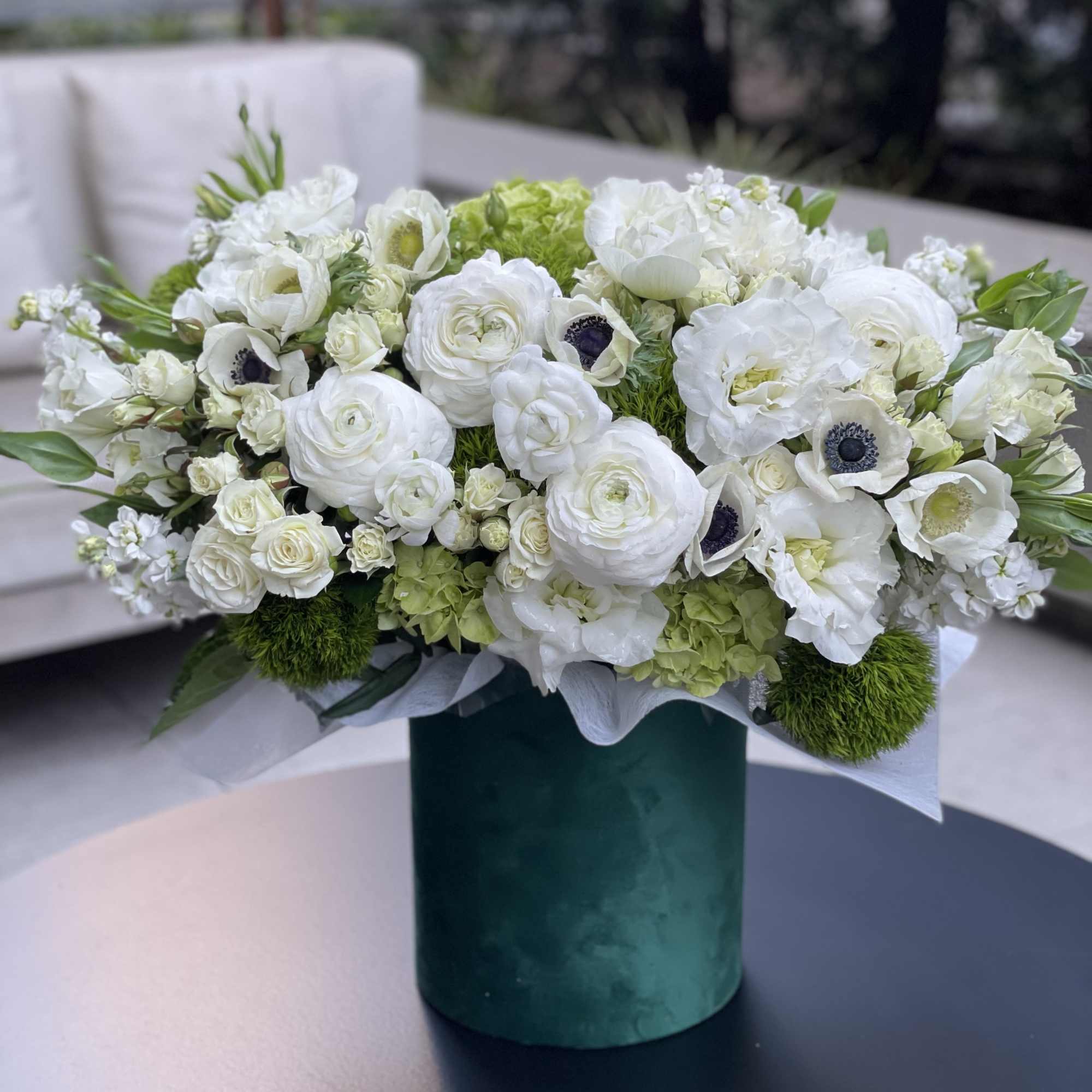 White floral arrangement in a green cylindrical vase, photo 3 of 9