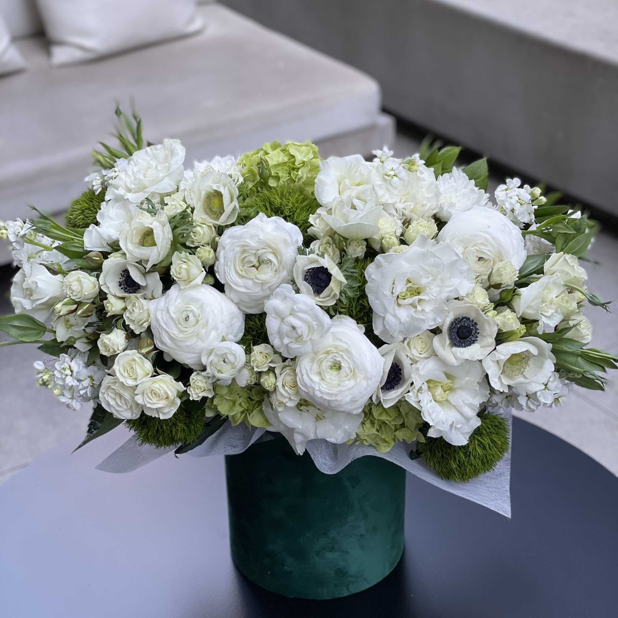 White floral arrangement in a green velvet box