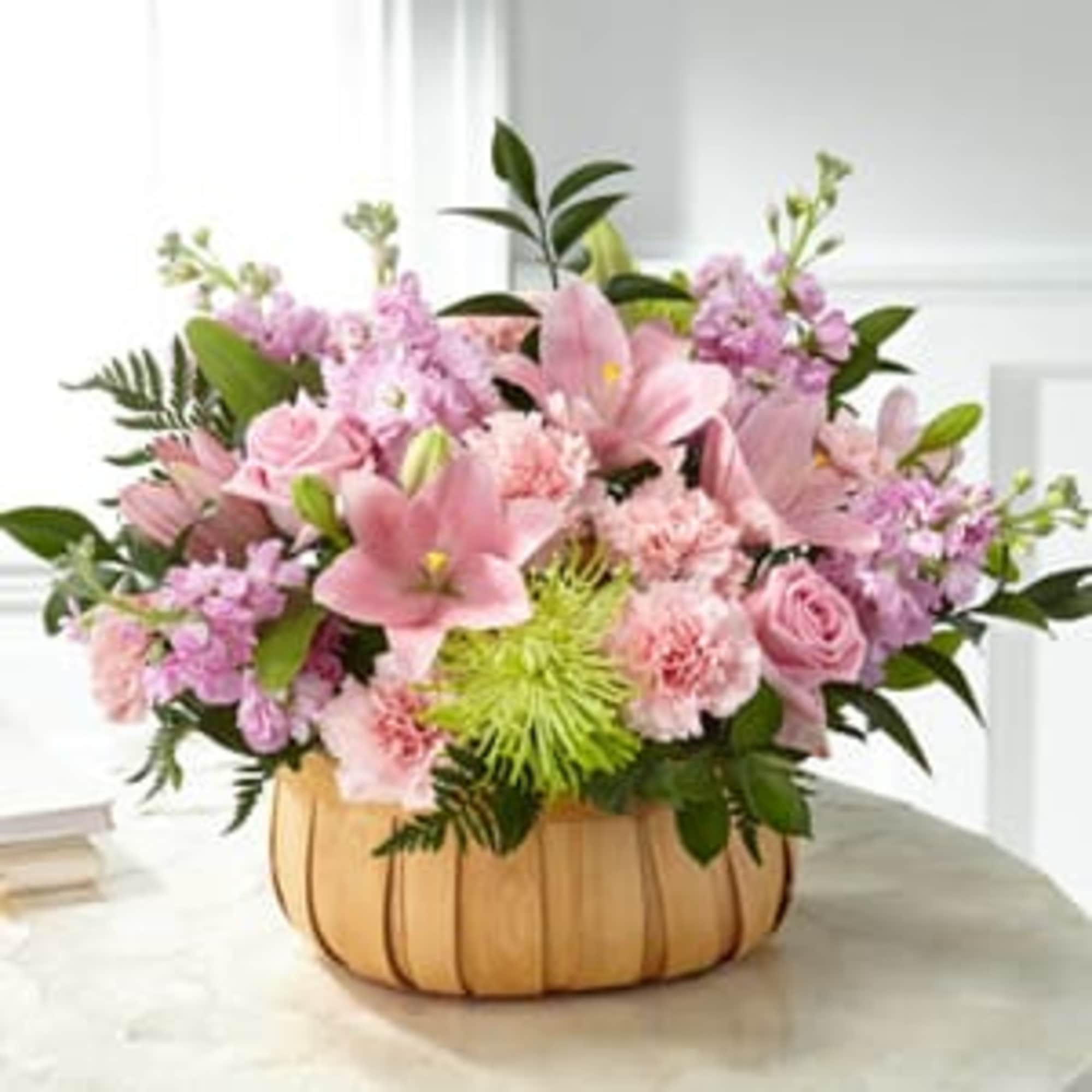 Pink floral arrangement in a pumpkin-shaped container