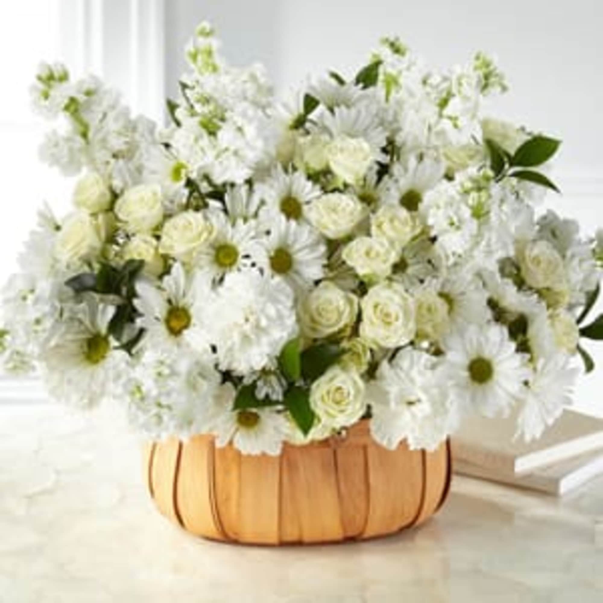 White daisies and roses arranged in a wooden basket