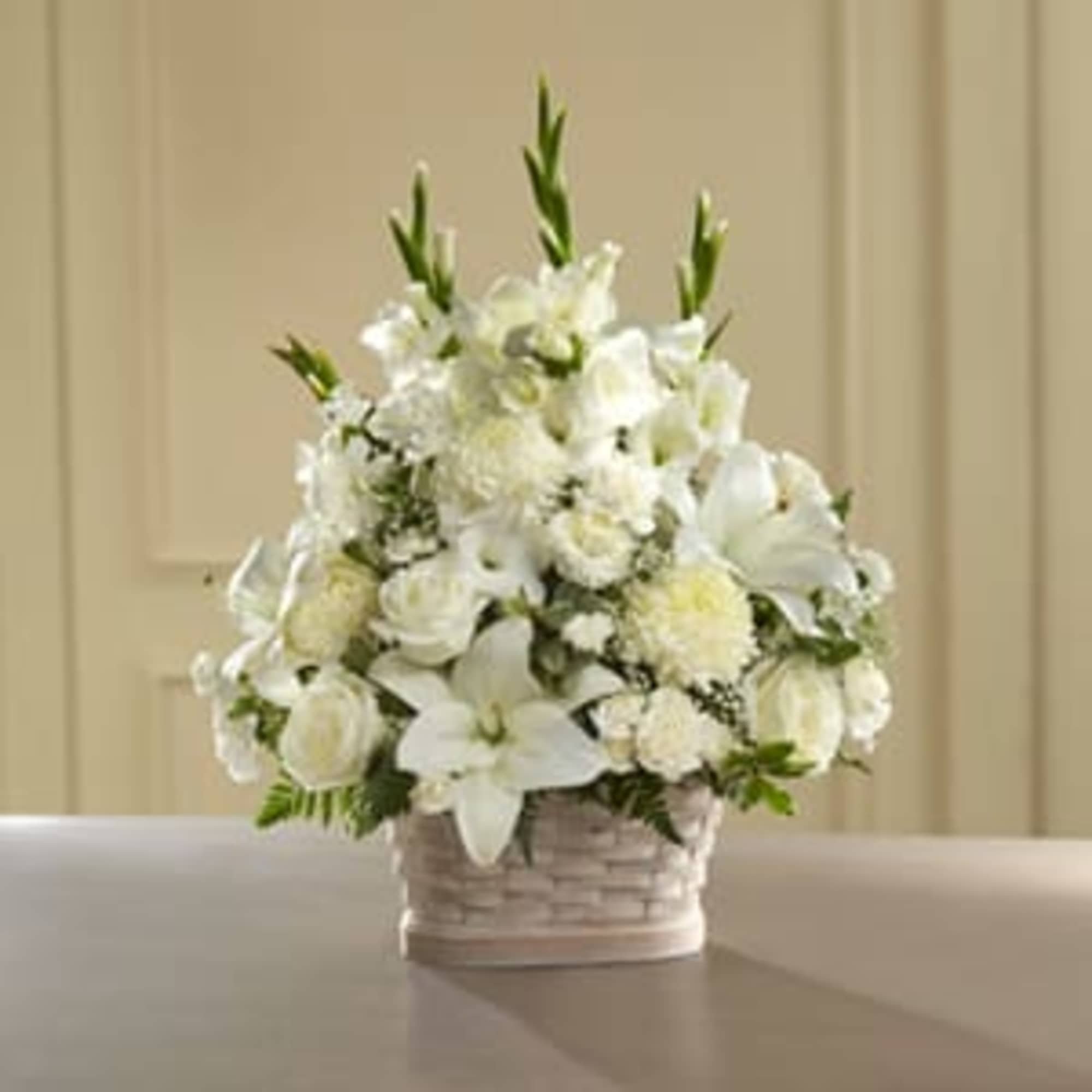 White floral arrangement in a woven basket on a table