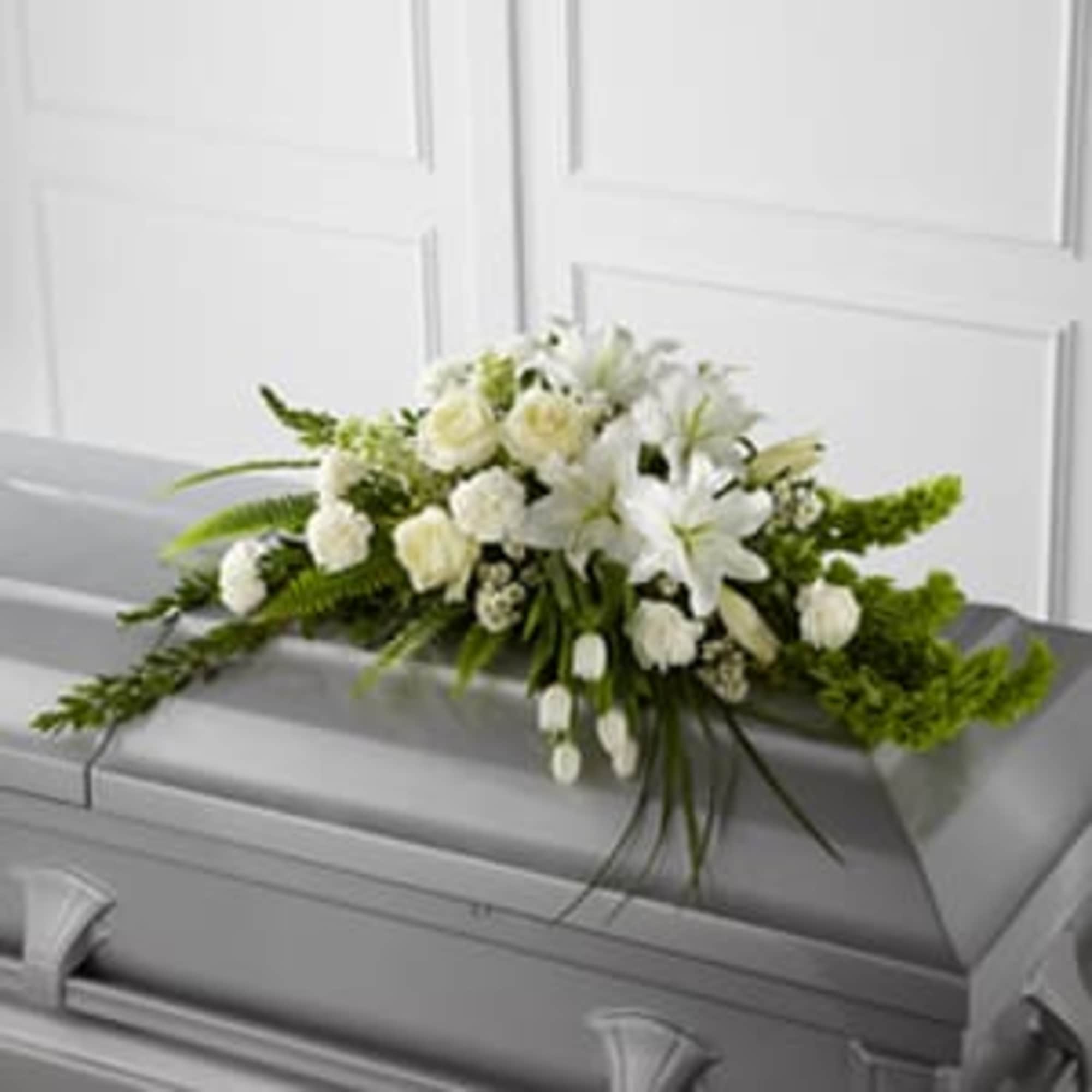 White floral spray on a gray casket