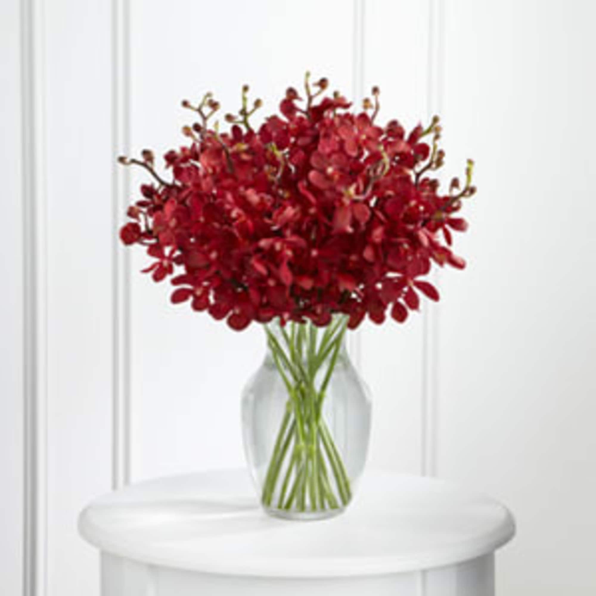 Red orchid bouquet in a clear glass vase