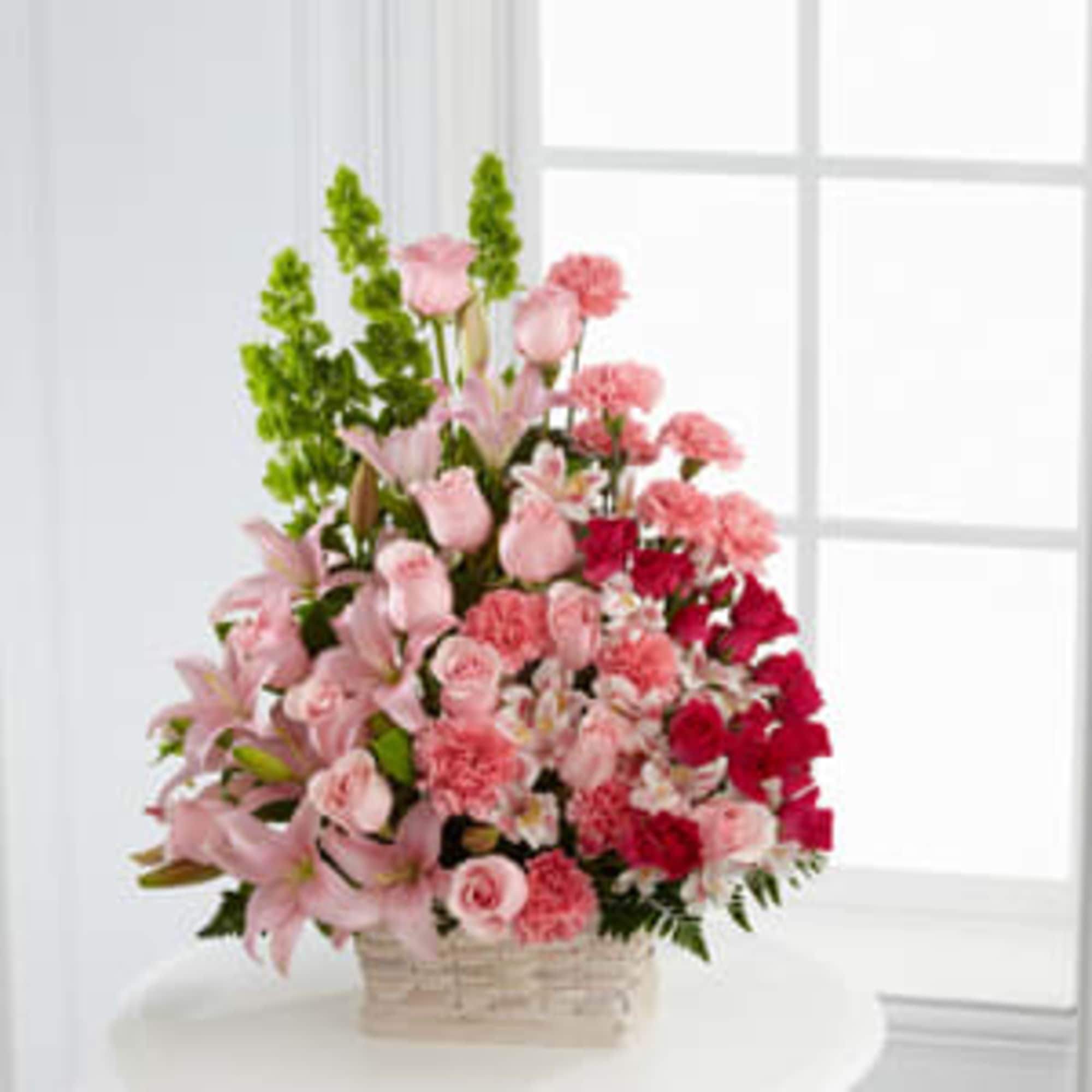 Pink and red mixed flowers in a wicker basket