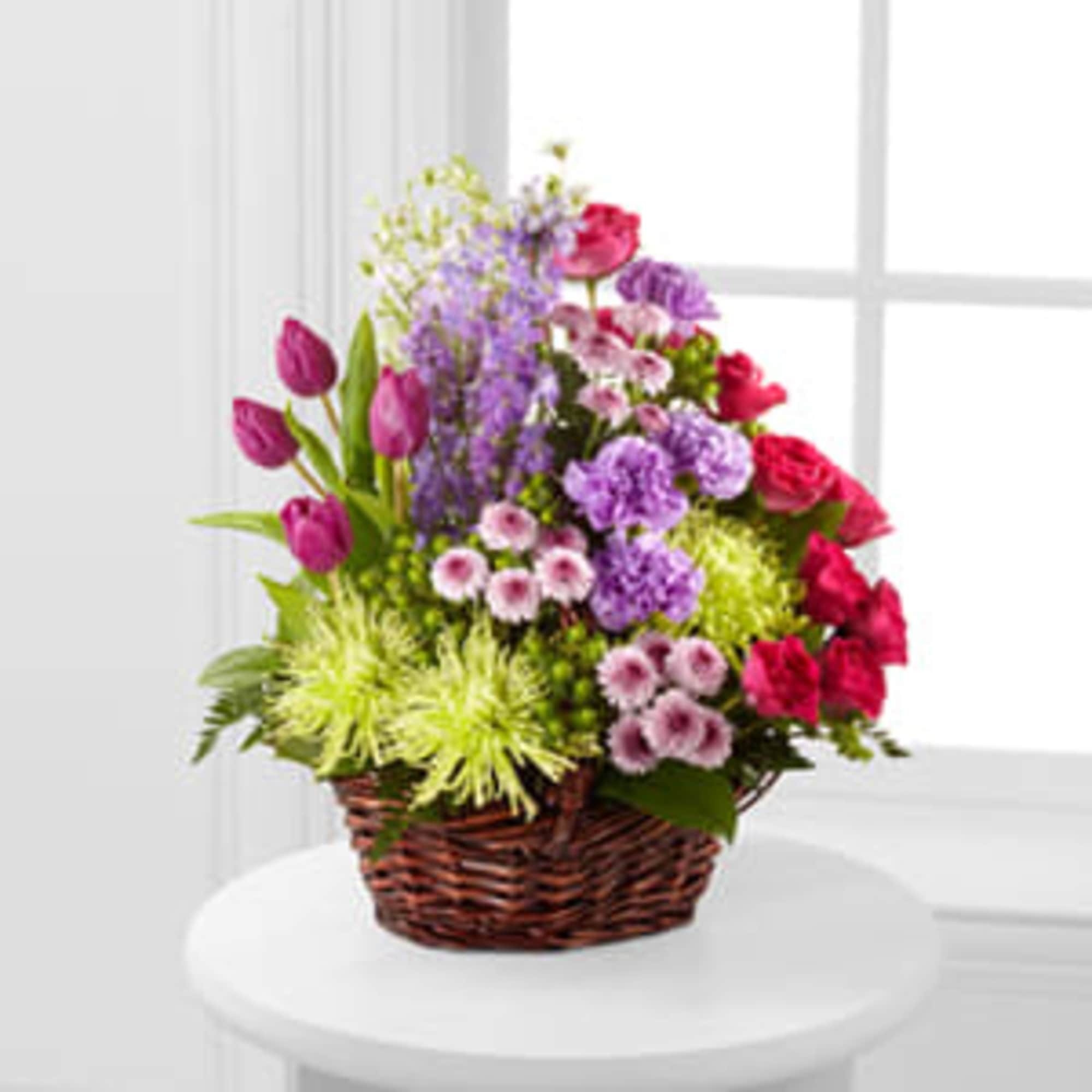 Mixed bouquet in a wicker basket with pink and purple flowers
