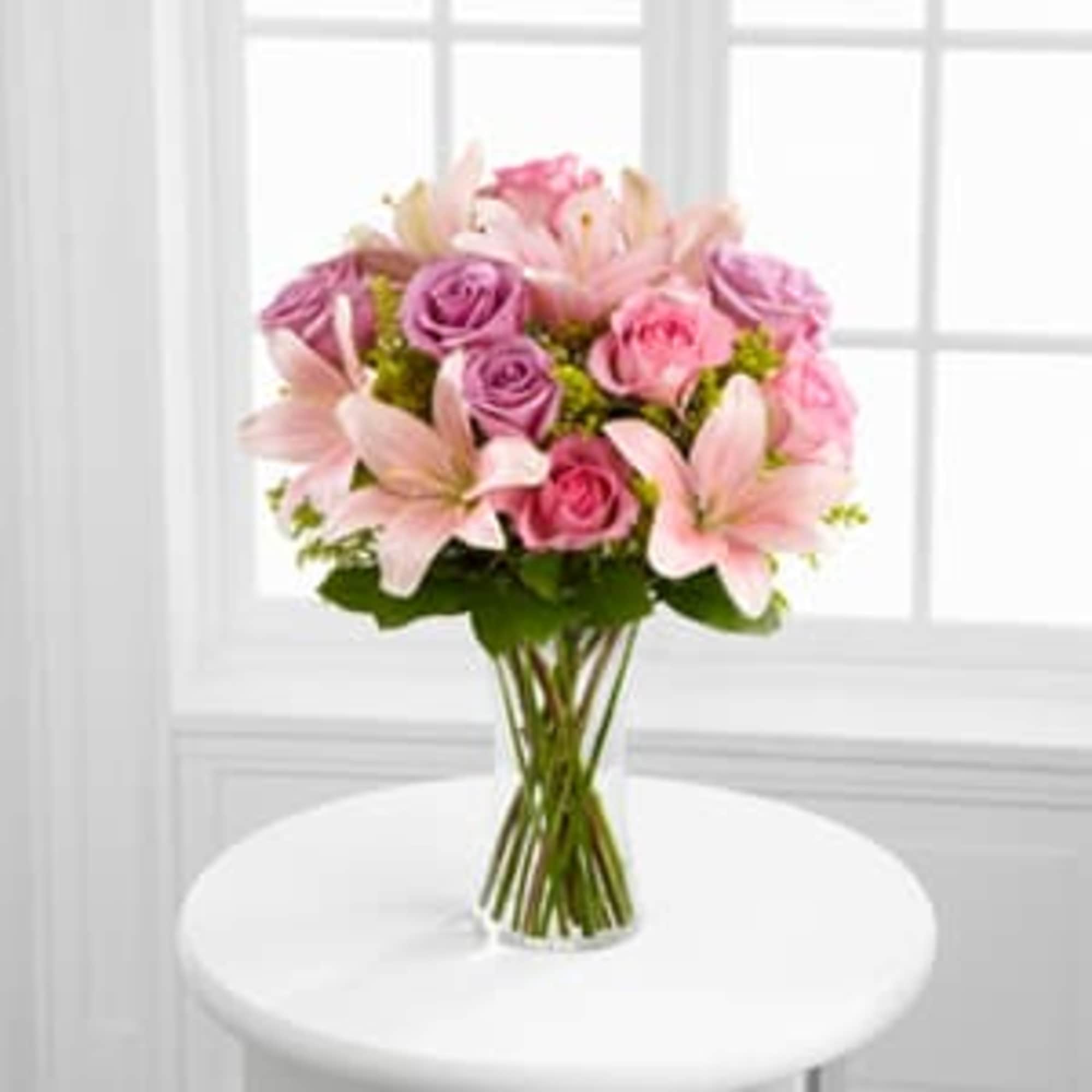 Bouquet of pink roses and lilies in a clear glass vase