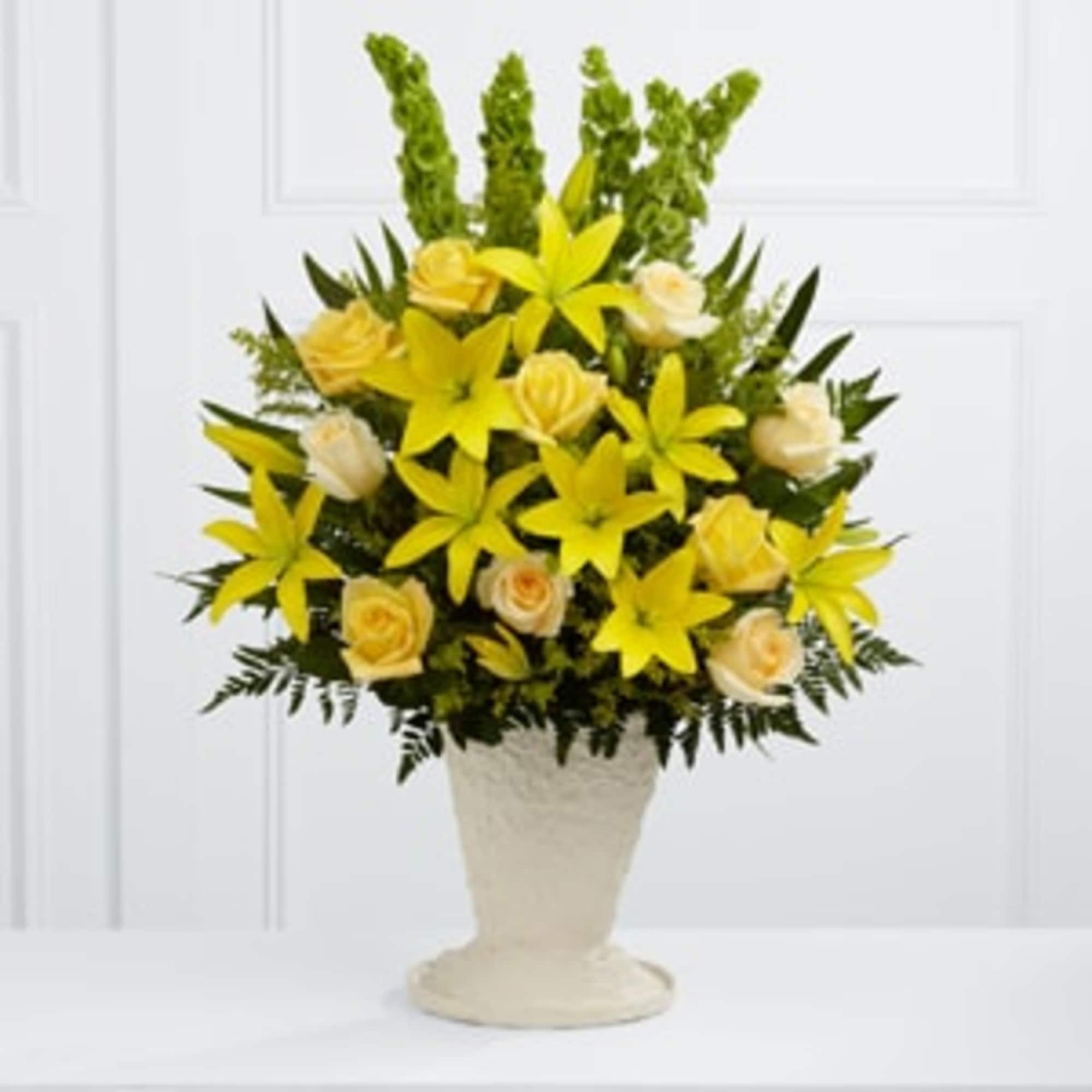 Yellow lilies and cream roses in a white vase
