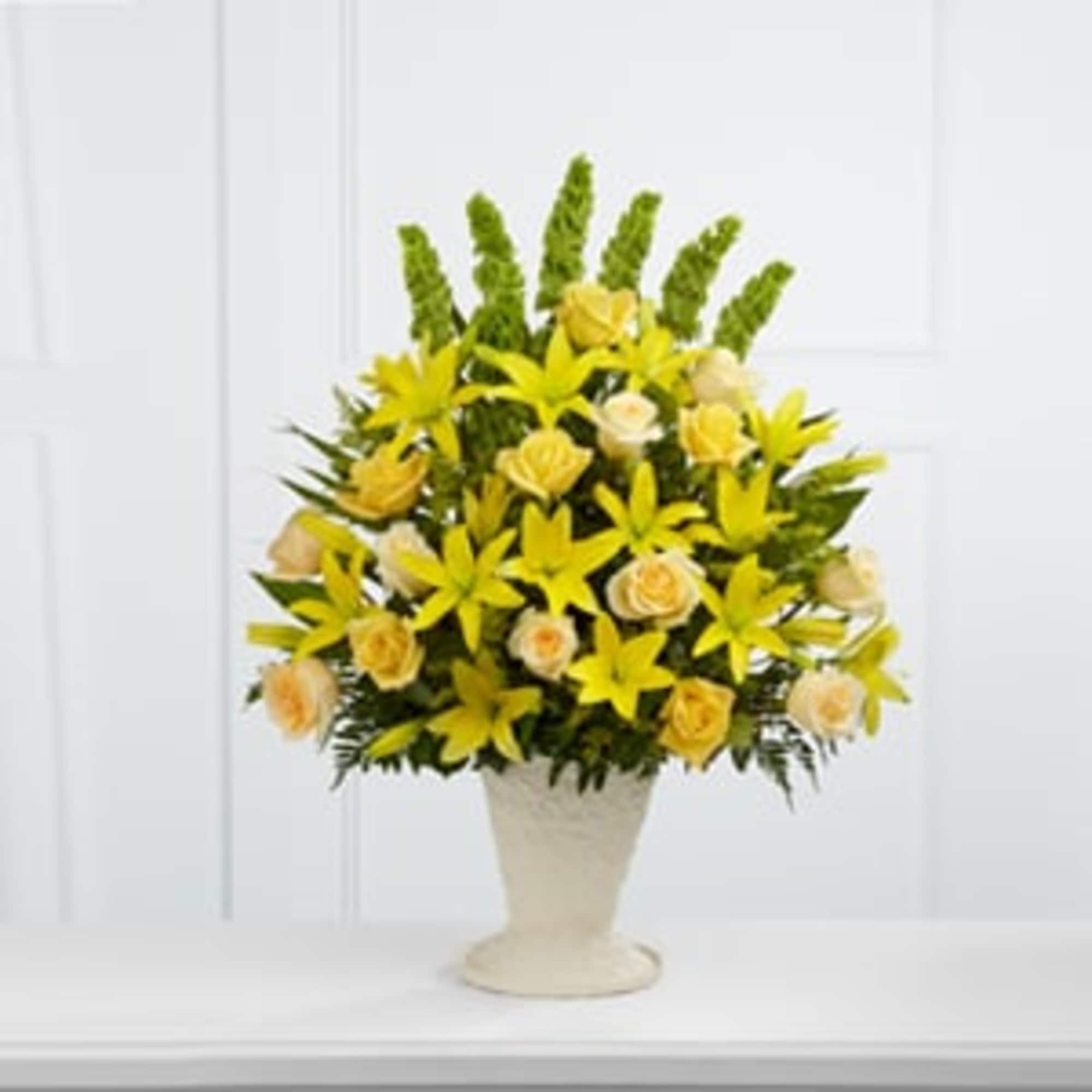 Yellow flowers arranged in a white pedestal vase