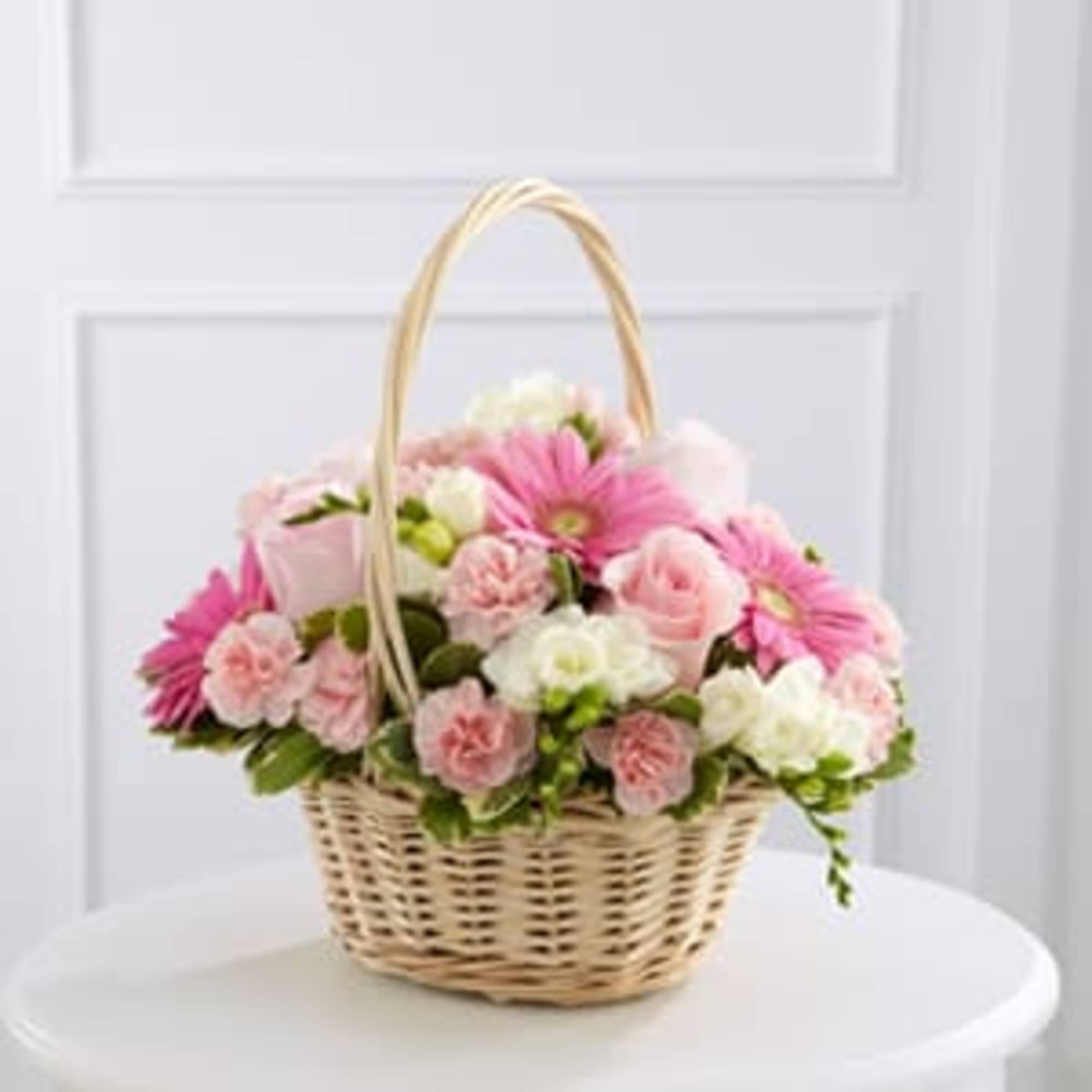 Basket of pink and white flowers with a tall handle