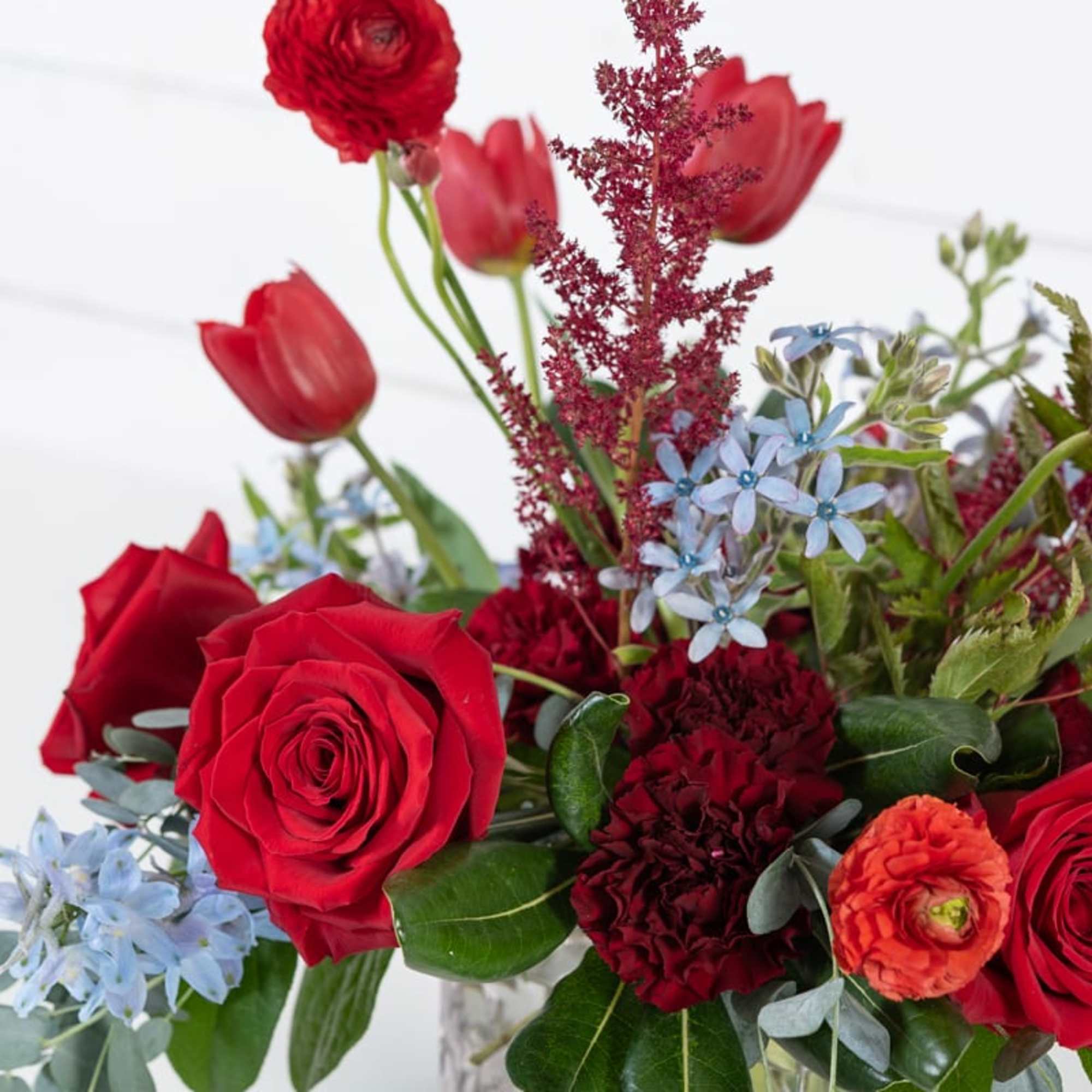 Red roses and tulips arranged in a clear square vase, photo 3 of 3