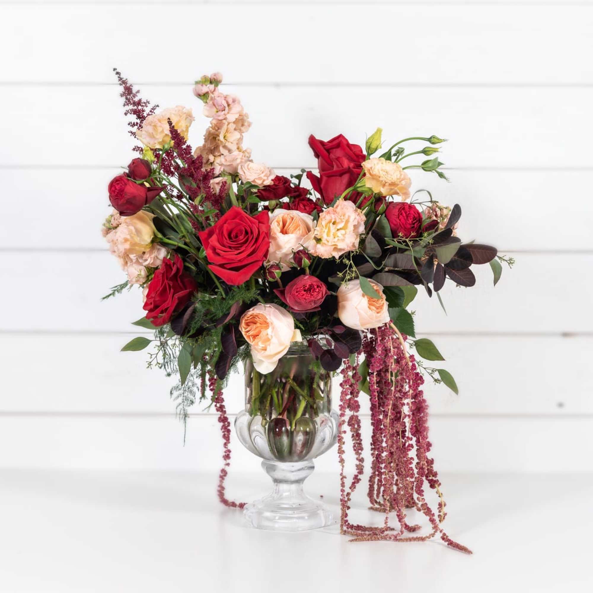 Red and blush roses in a clear glass vase