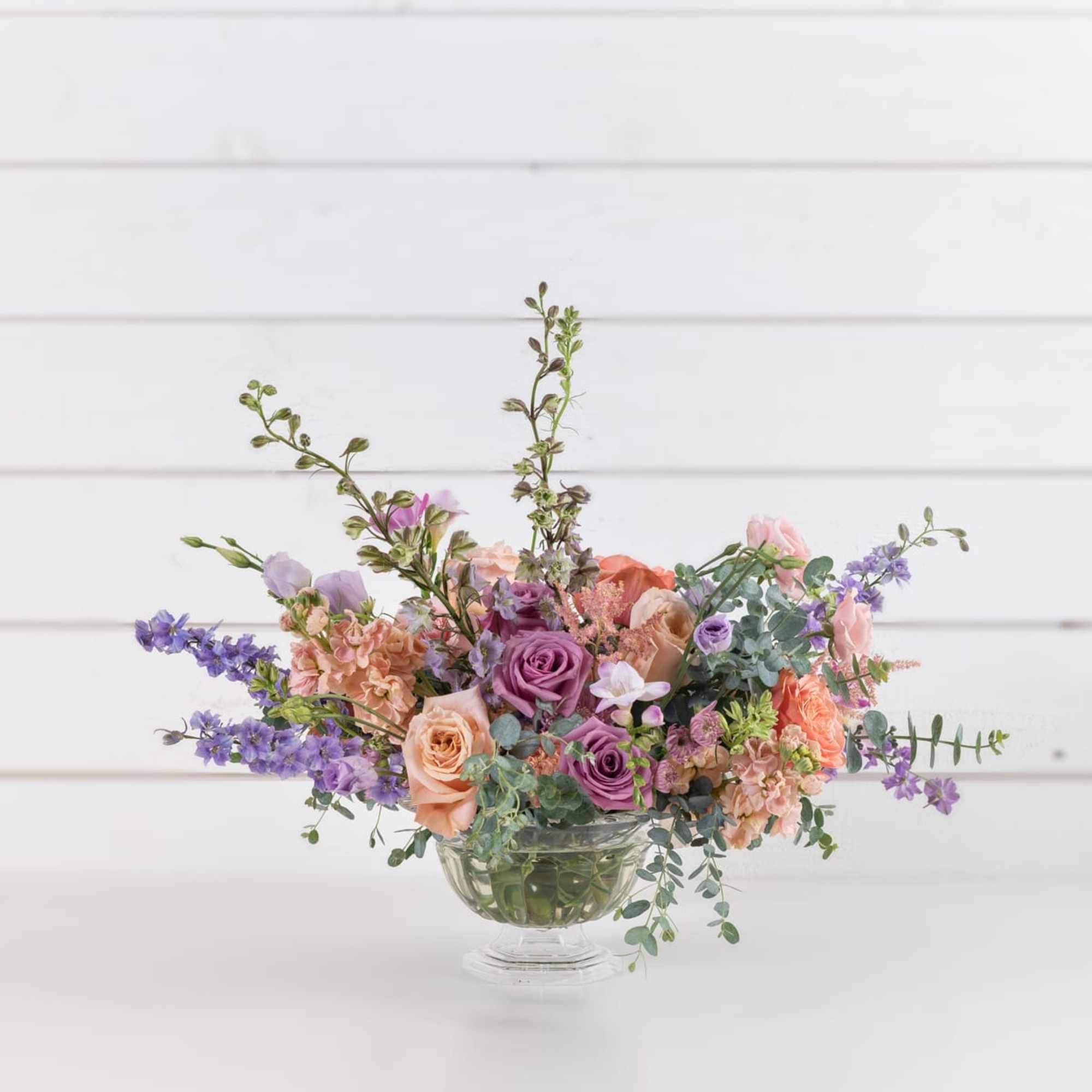Pastel mixed flower arrangement in a clear glass vase