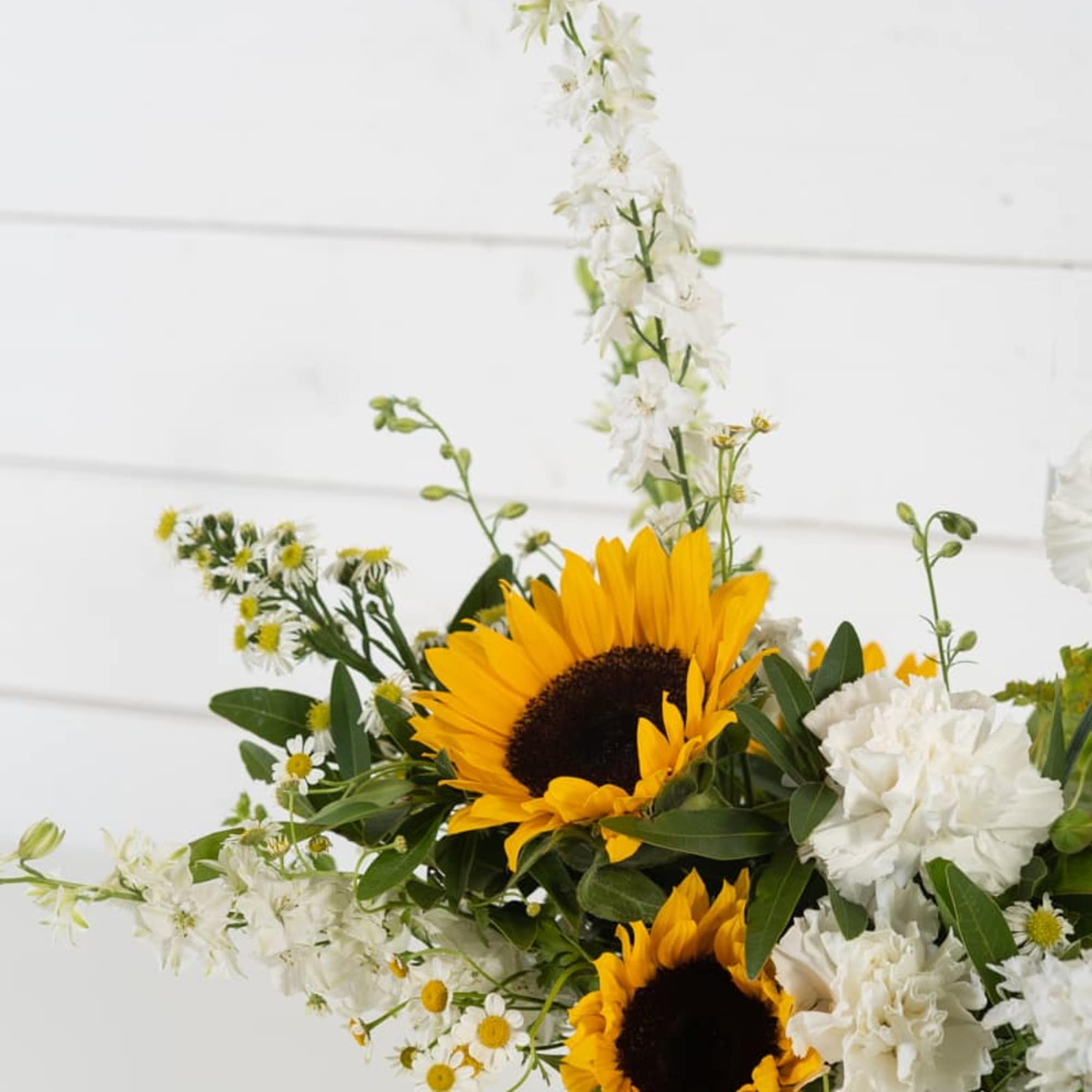 Sunflower and white flower arrangement in a clear glass vase