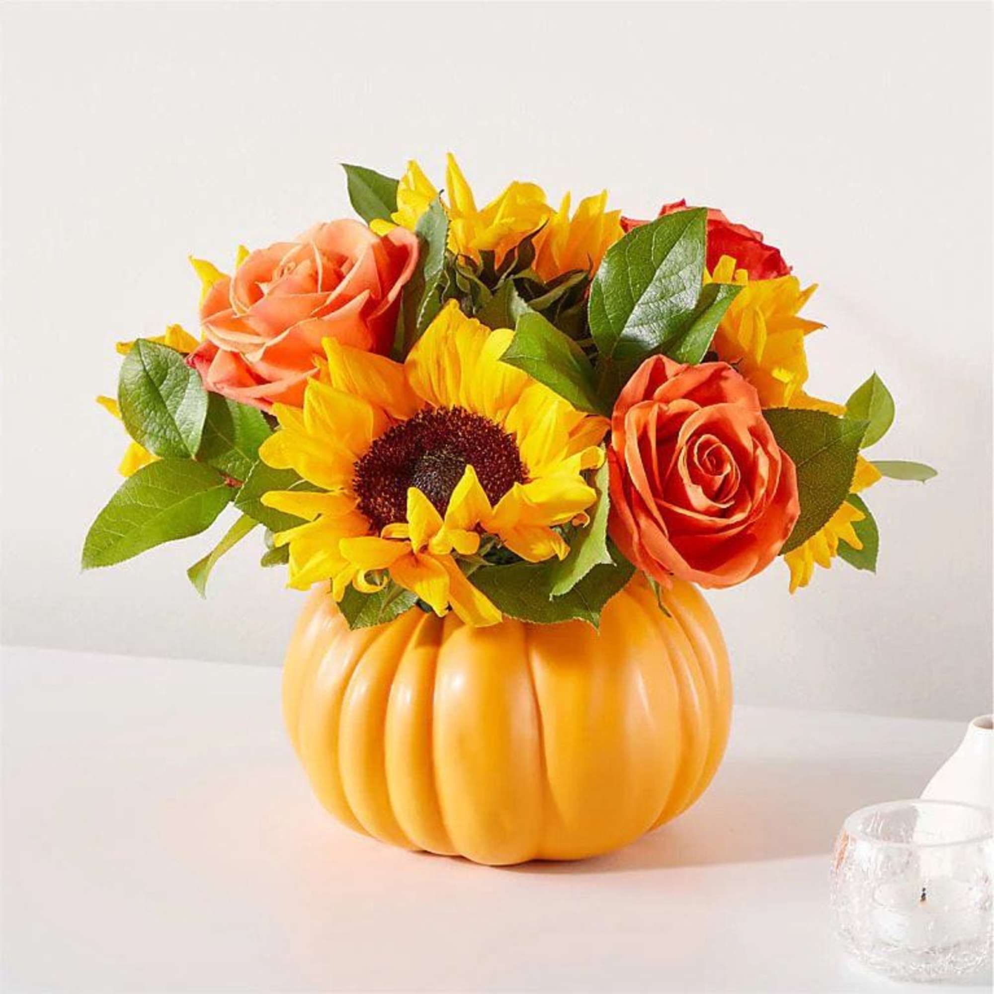 A bright and colorful centerpiece arranged in a ceramic pumpkin container. This