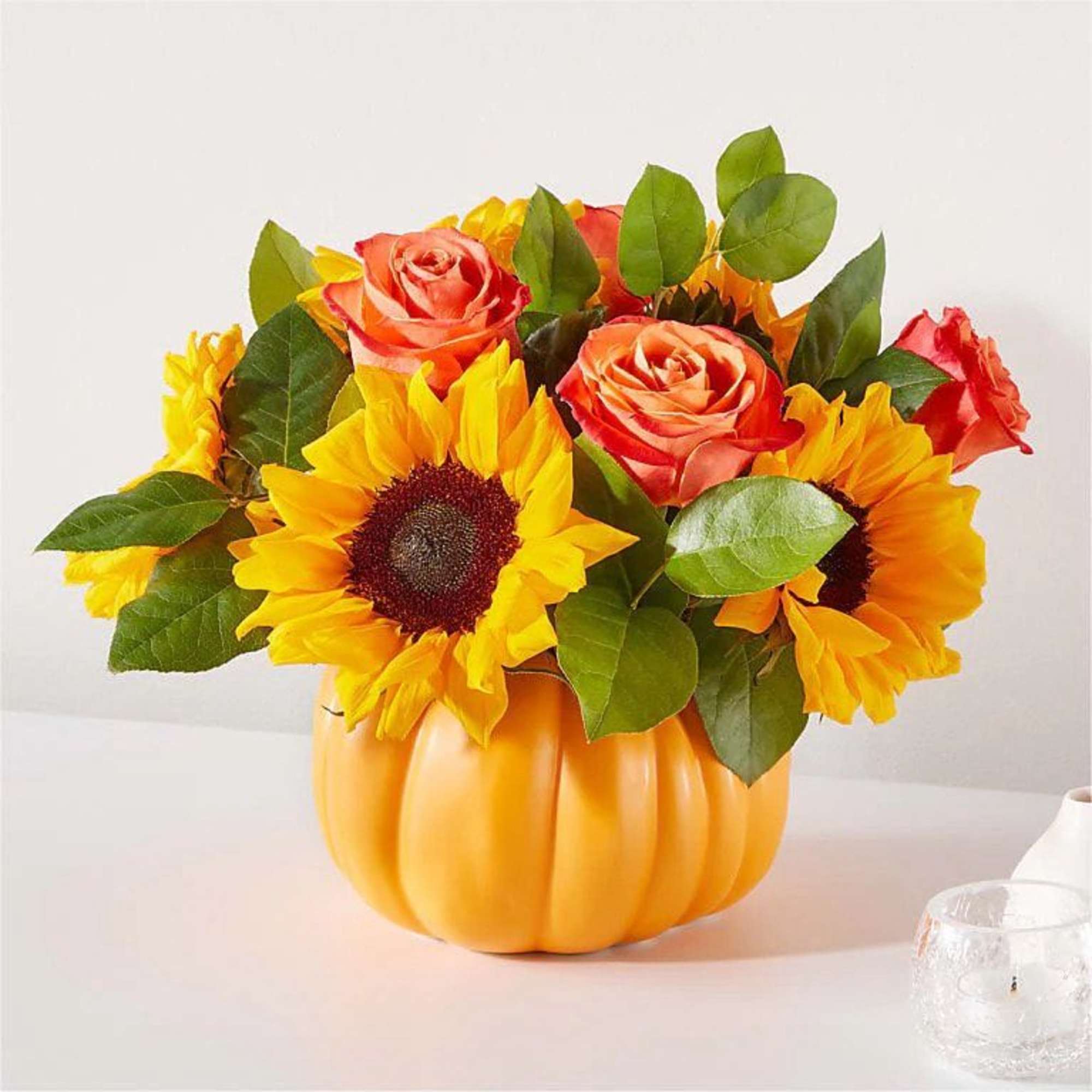 A bright and colorful centerpiece arranged in a ceramic pumpkin container. This